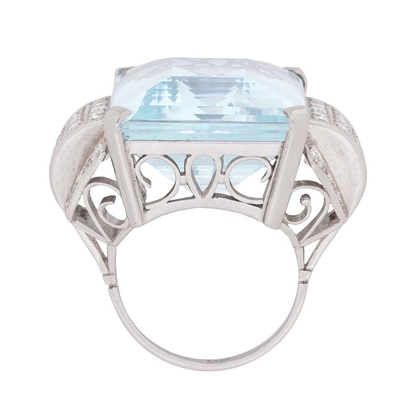This gorgeous aquamarine and diamond ring of epic proportions was exquisitely handcrafted in platinum during the fabulous ’40s!

The ring stars a dramatically beautiful, 34.15 carat, placid blue, emerald cut aquamarine, which has been corner claw