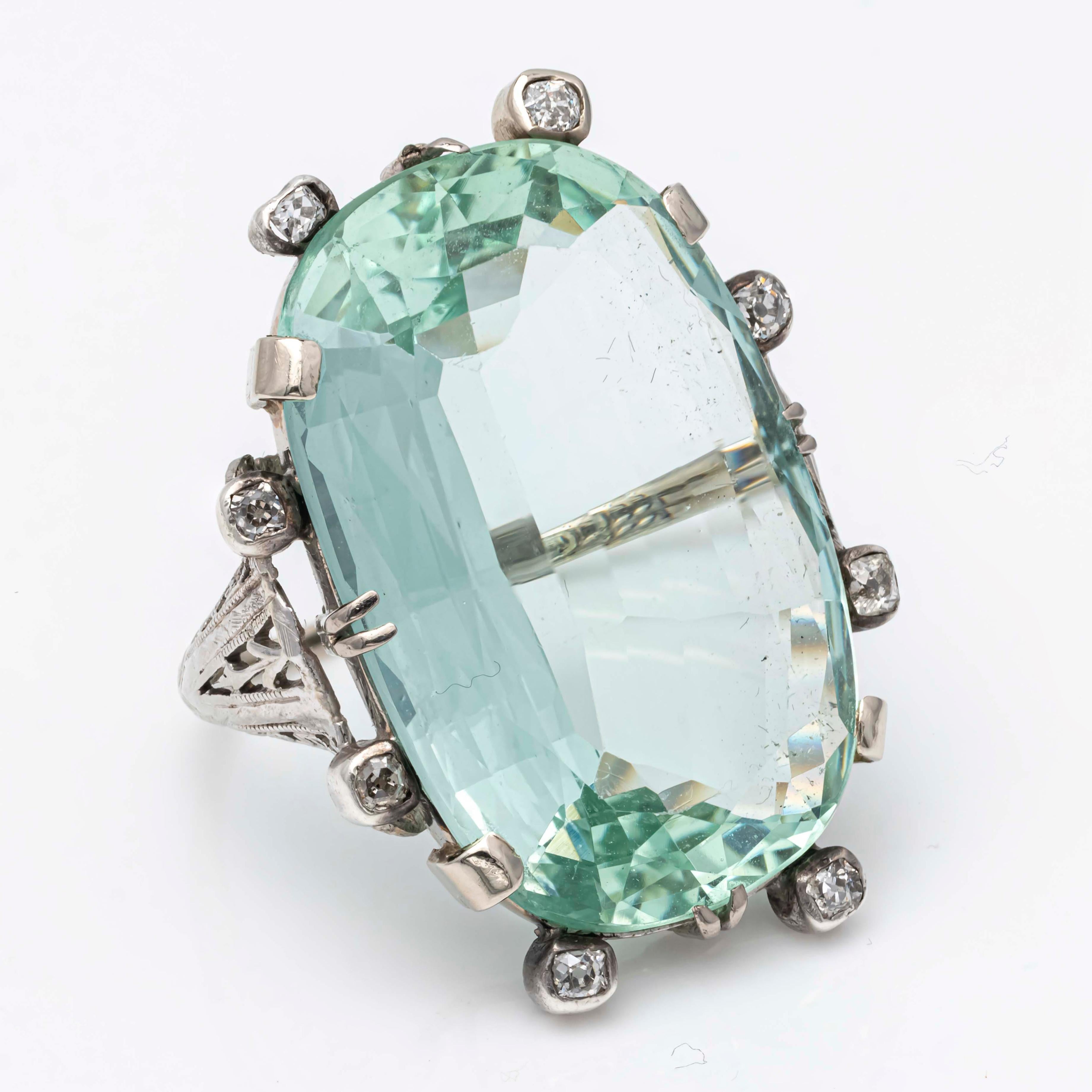 A beautiful large cocktail ring, featuring a 34.18 carats natural green aquamarine stone, set in an intricate antique ring design. Accented by 8 old mine cut diamonds weighing 0.42 carat total. Finely made with an 18K white gold mounting. Size 7.5