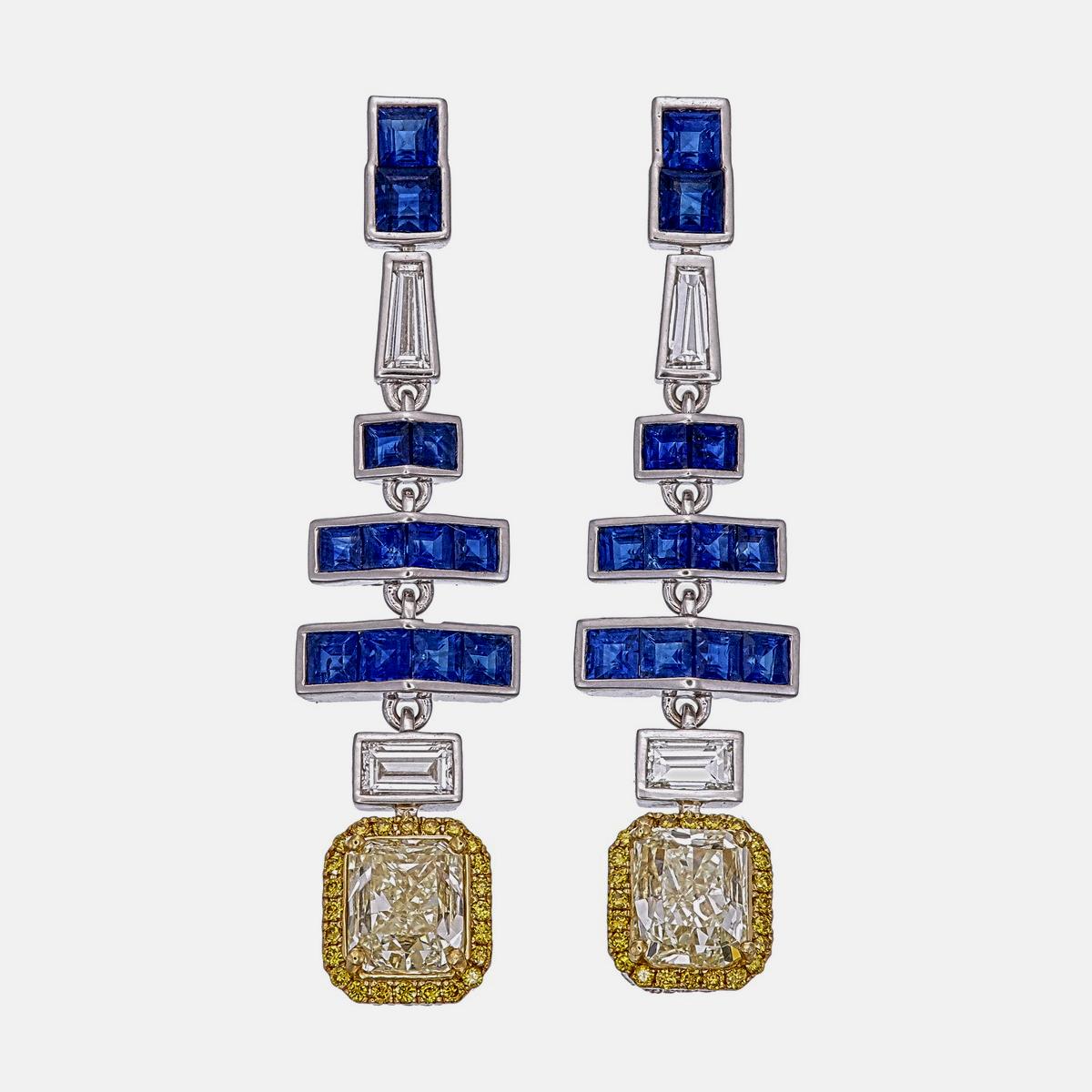 Los elegantes pendientes de zafiro azul y diamantes de Rewa jewels están hechos a mano en oro blanco de 18 quilates.

Tiene 24 piezas de zafiros azules de forma cuadrada con un peso aproximado de 3,42 quilates. Los zafiros de este tamaño y color son