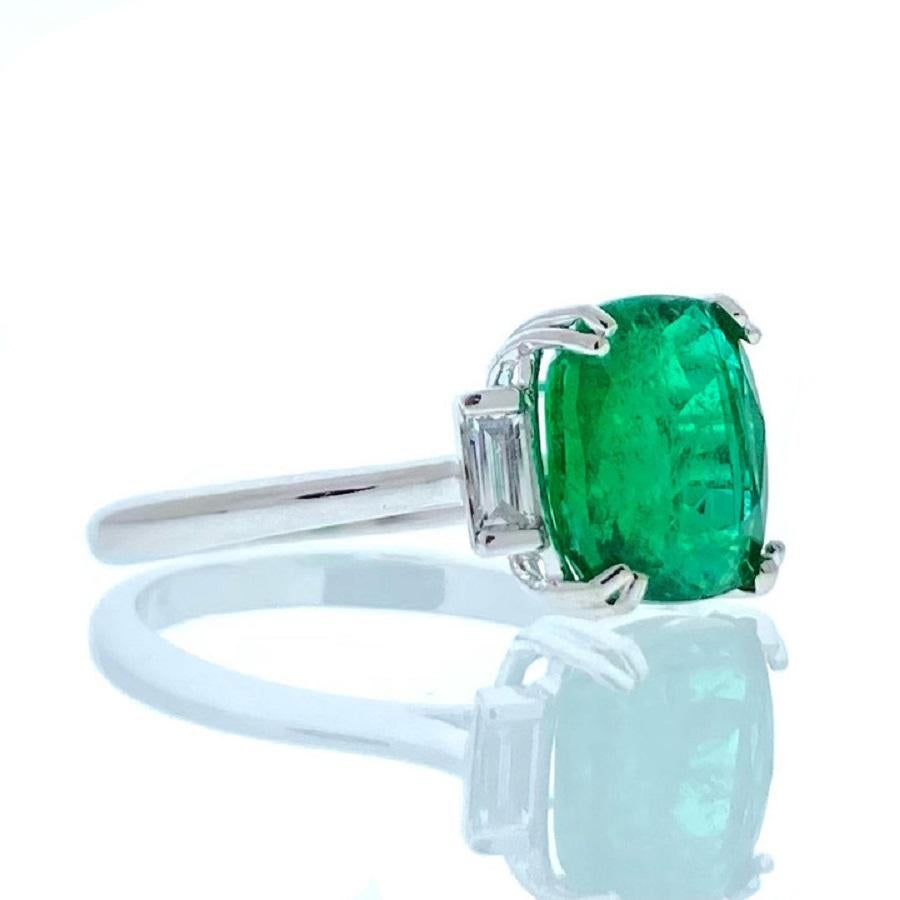 This ring epitomizes elegance and refinement with its captivating design. Crafted in 14 karat white gold, it features a breathtaking 3.42 carat cushion-shaped green emerald as its centerpiece. The emerald's lush green hue exudes natural beauty and