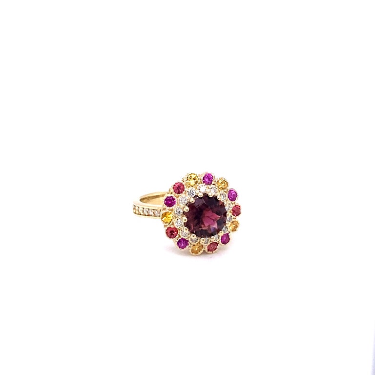 This Ring has a Round Checkered Cut Tourmaline that weighs 2.33 Carats and 14 Multi Sapphires that weigh 0.73 Carats. There are also 26 Round Cut Diamonds that weigh 0.36 Carats.  The Clarity and Color of the Diamonds is: SI2, F
The Total Carat