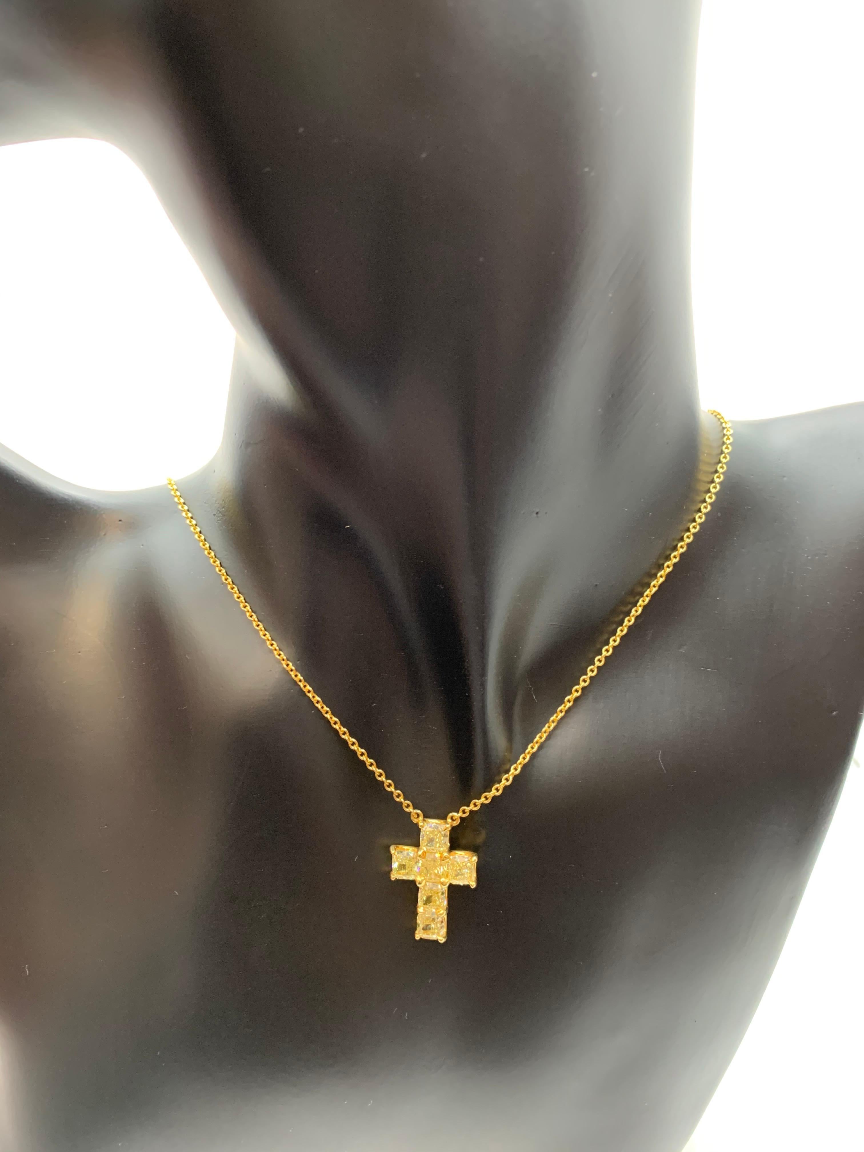 This cross features 6 perfectly matched Cushion Cut  Yellow Diamonds weighing 3.44 Carats and set in a minimalistic setting that lets light pass from all directions. 
Set in 18 Karat Yellow Gold.
Chain can be worn at the neck bone at 15.5 inches or