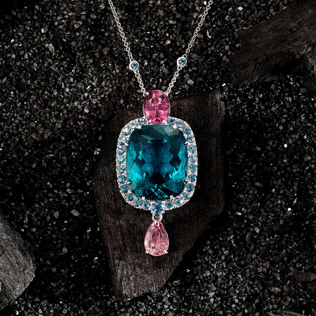 Our La Fete du Blue Necklace features an astonishing 34.43 carat Cushion Cut deep teal coloured Apatite at its heart, surrounded by a halo of round Aquamarines (total weight of all aquamarine stones is 2.203 carats). This divine necklace also