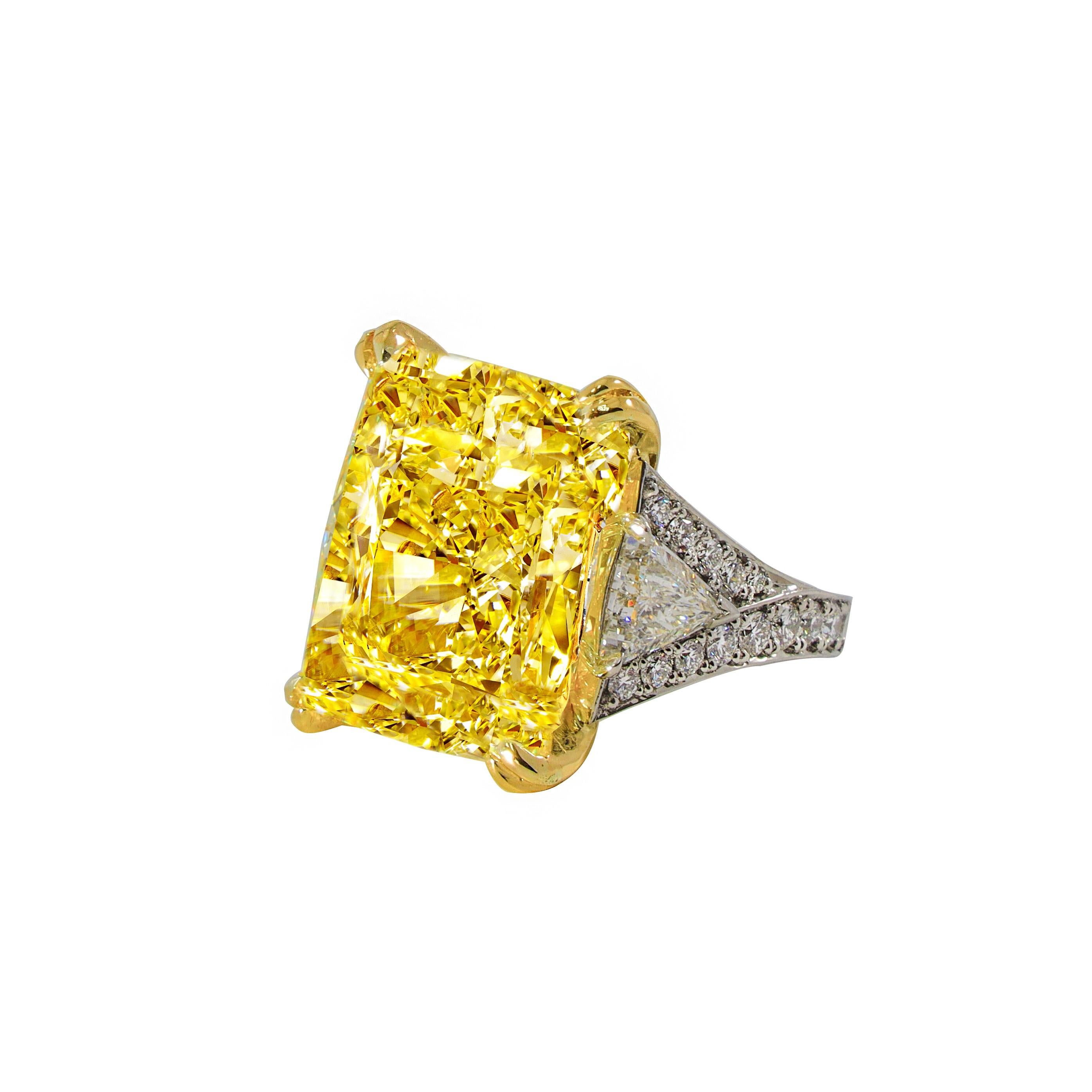 Magnificent radiant cut diamond ring is the Highlight of the Diana M. Jewels. Speechless 34.46 Carats Fancy Intense Yellow Radiant Cut  VS2 in clarity. Certified by GIA set with 3.20 Carats of two impressive trillion diamonds set in Platinum.


