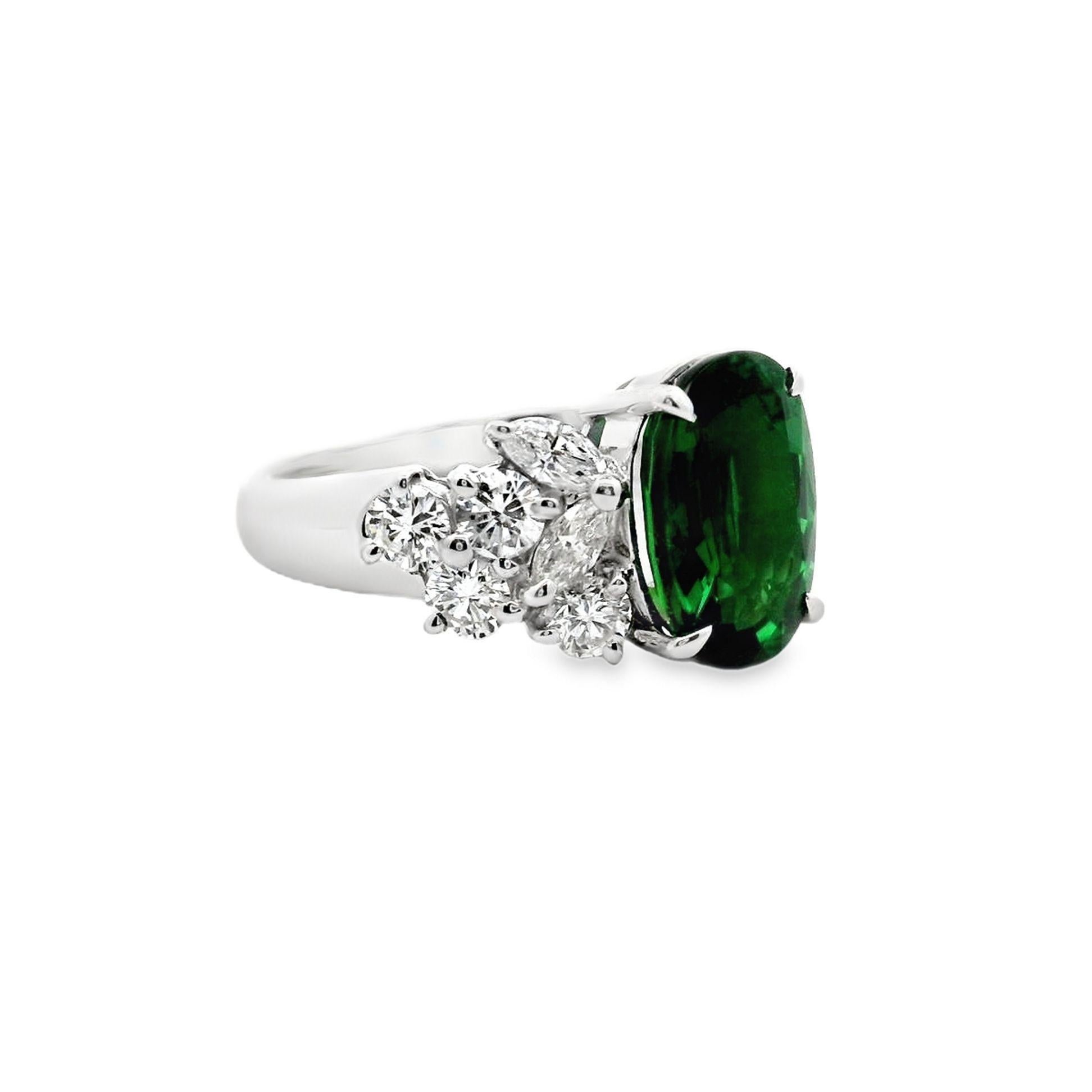 A lovely contemporary ring crafted in platinum, featuring a fine gem 3.45-carat oval-cut green tsavorite garnet. The tsavorite has a rich intense green color that makes this gem famous and is flanked by 1.10 carats of marquise and round