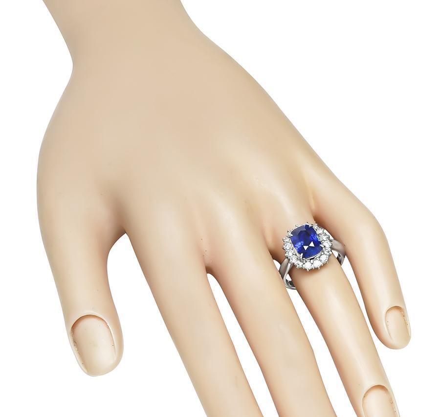 Se trata de un elegante anillo de compromiso de platino. El anillo está centrado con un precioso zafiro talla cojín que pesa aproximadamente 3.45 ct. El zafiro está acentuado por brillantes diamantes de talla redonda que pesan aproximadamente 0.57