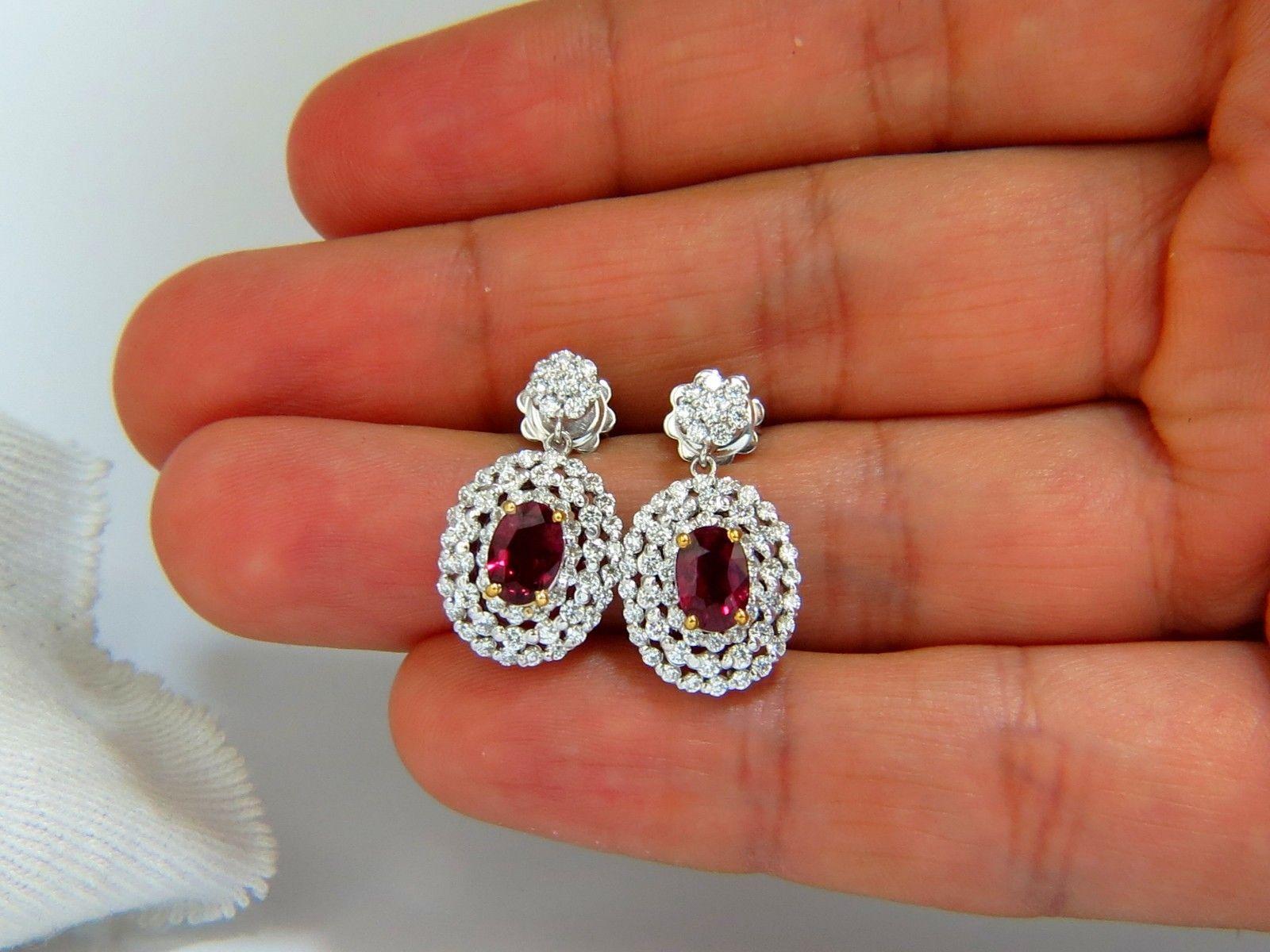 Ruby dangle cluster earrings.

1.86ct natural oval red rubies 

Clean Clarity & Transparent

6.8 X 4.9mm each

1.60ct. Natural diamonds  

Rounds, Full cut brilliants.

G- color Vs-2 Clarity. 

Secure push backs

Excellent detail.

14kt. white