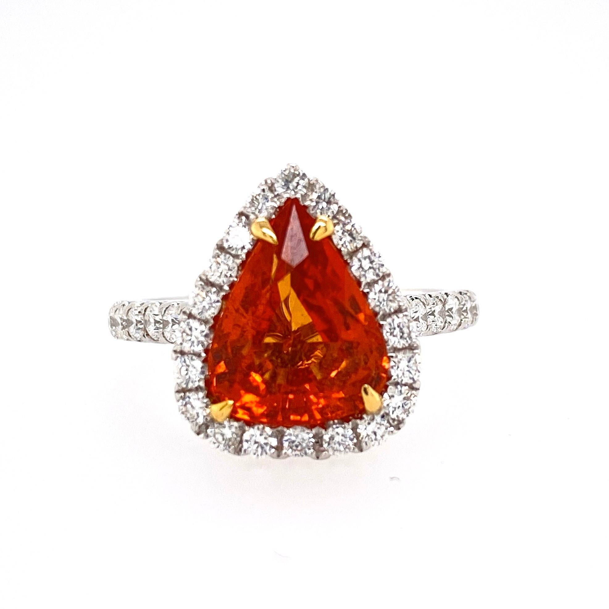 This beautiful cocktail ring features a stunning 3.46 Carat Pear Shape Orange Sapphire with a Diamond Halo, on a Diamond Shank. This ring is set in 18k White Gold, with 18k Yellow gold prongs on the center stone. Total Diamond Weight = 0.67 Carats.