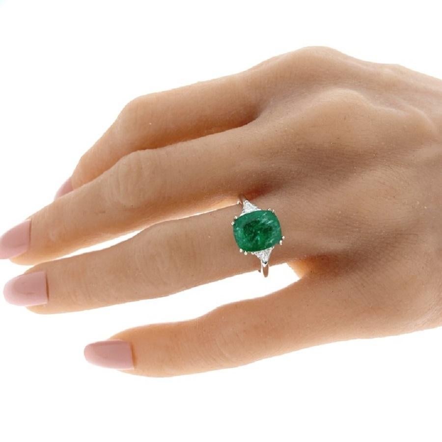 This ring is a stunning embodiment of sophistication and allure. Crafted in 14 karat white gold, it showcases a magnificent 3.47 carat cushion-shaped green emerald at its center, radiating a deep and captivating hue that exudes timeless elegance.