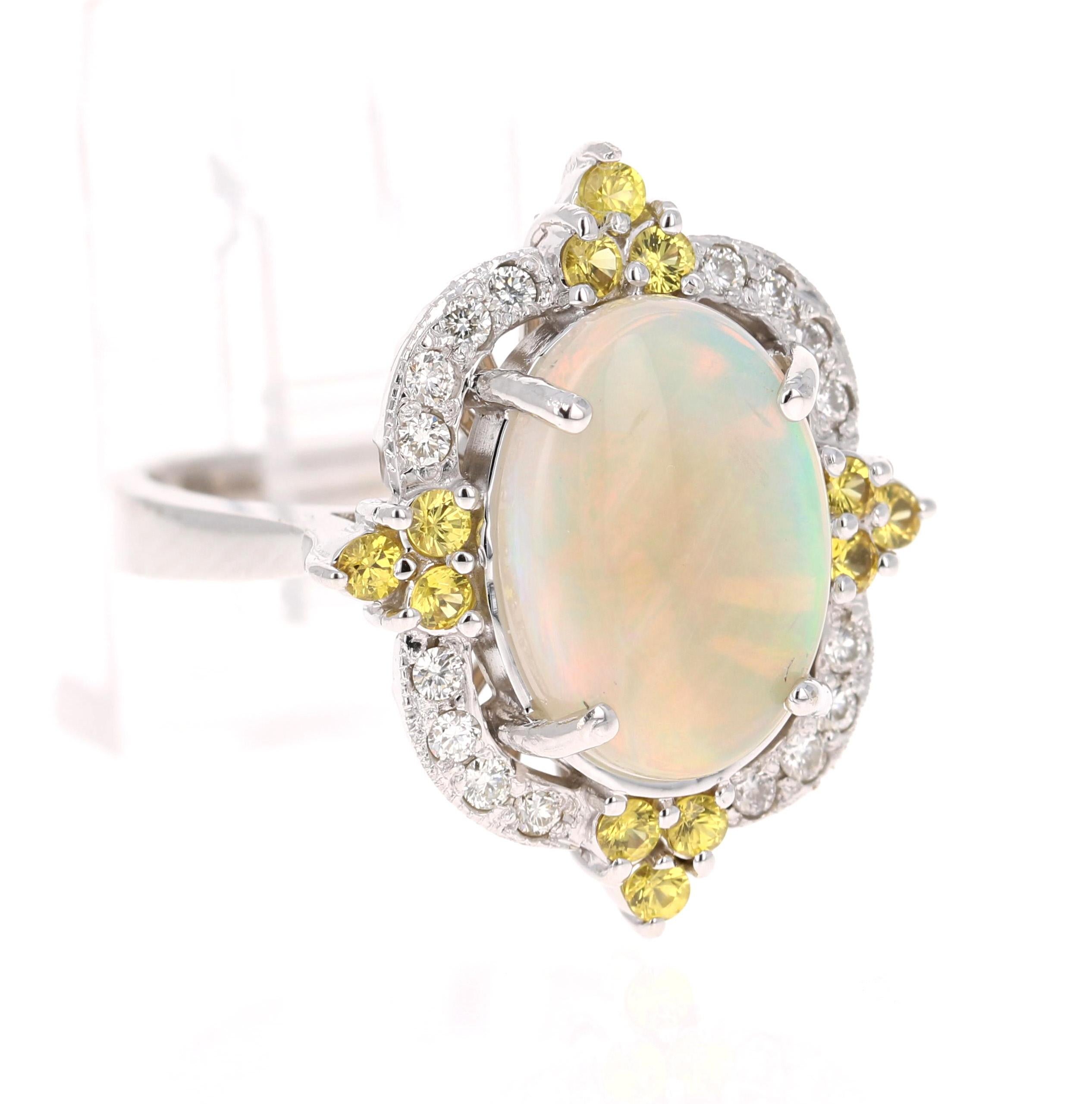 Opulenter Ring mit Opal, gelbem Saphir und Diamant aus 14 Karat Weißgold.

Der wunderschöne Opal im Ovalschliff äthiopischen Ursprungs mit seinen auffälligen Farbschattierungen wiegt 2,78 Karat. Der Opal hat Farbschattierungen von Grün, Orange, Gelb