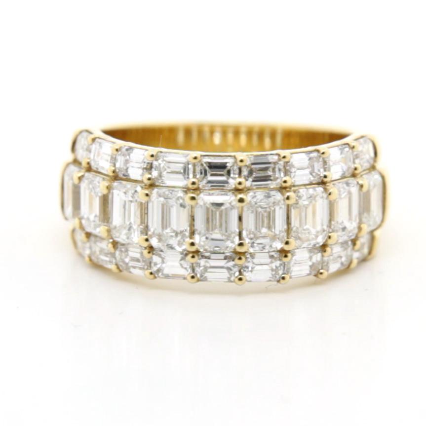 Symphonie d'or : la bague à diamant en taille émeraude fluide

Cette bague extraordinaire est un véritable chef-d'œuvre de précision et d'élégance, conçu pour mettre en valeur l'éclat intemporel des diamants taille émeraude dans un arrangement
