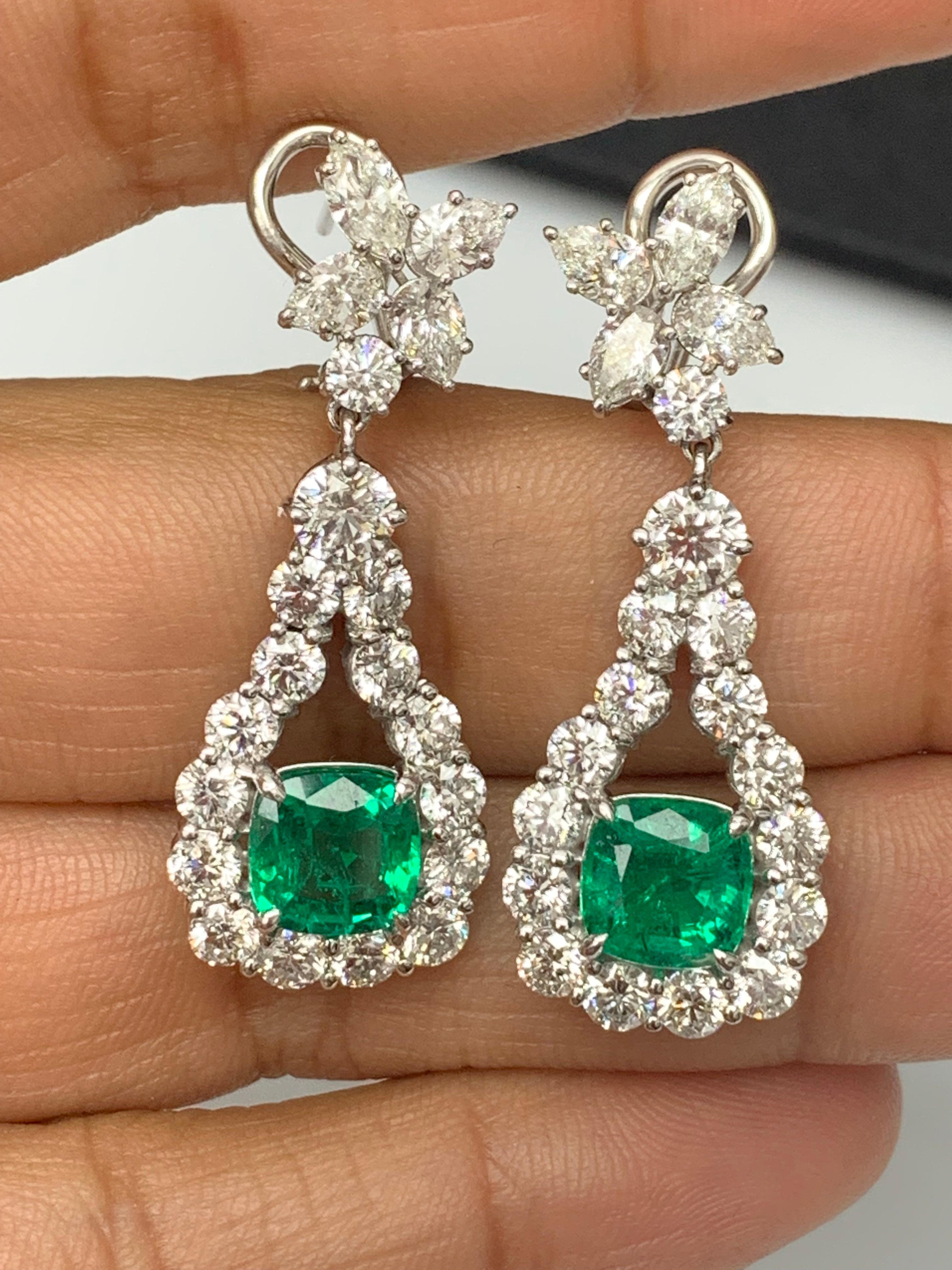A beautiful and chic pair of drop earrings showcasing a cluster of brilliant mixed-cut diamonds, and cushion-cut emeralds set in an intricate and stylish design. 8 Mixed cut Diamonds weigh 1.62 carats in total. 2 vivid green emeralds weigh 3.49