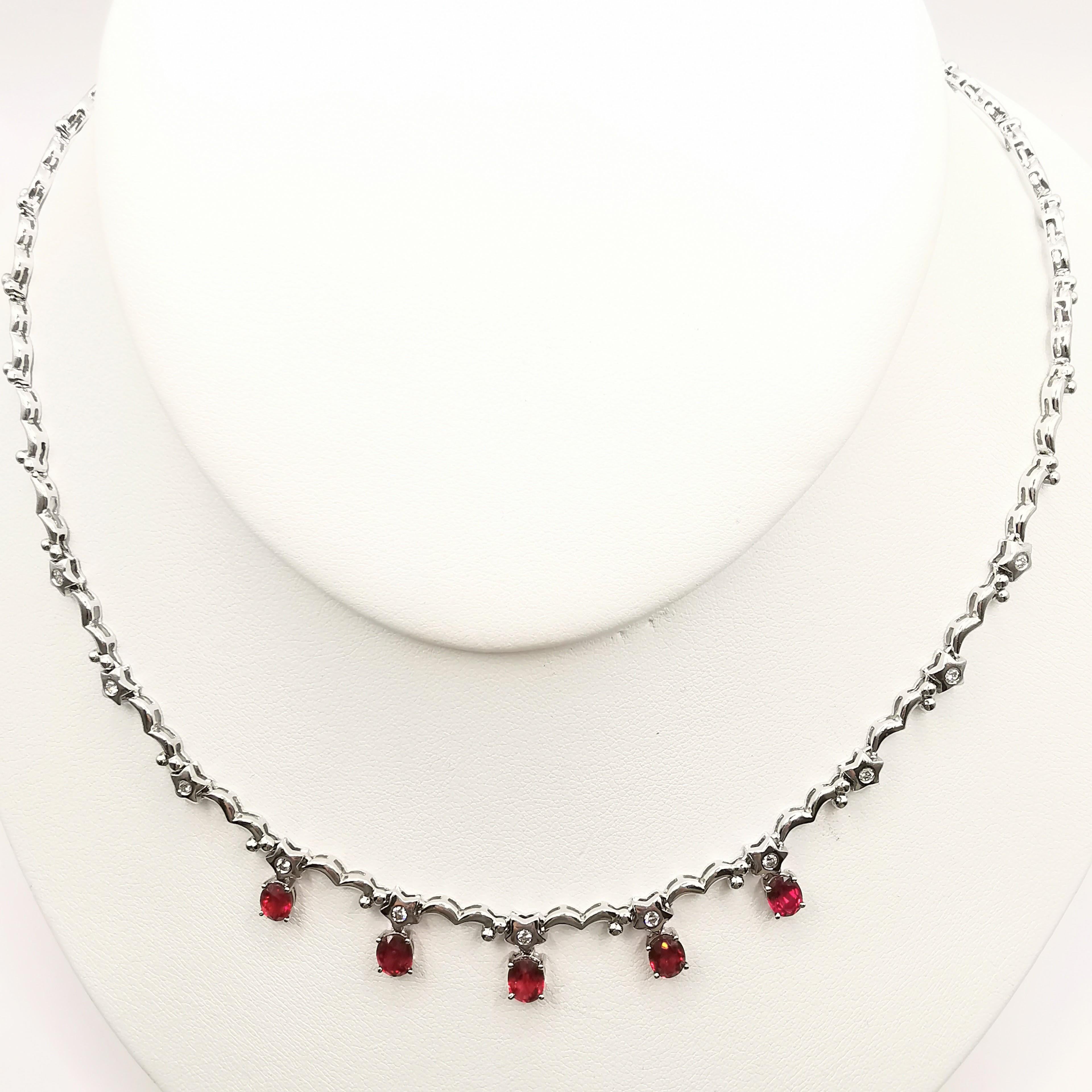 Introducing our exquisite 3.49 Carat Natural Oval Cut Pigeon Blood Ruby and Diamond Necklace, expertly crafted in 18K white gold. The necklace features five natural oval cut Pigeon Blood Rubies, with a total weight of 3.47 carats. The rubies boast