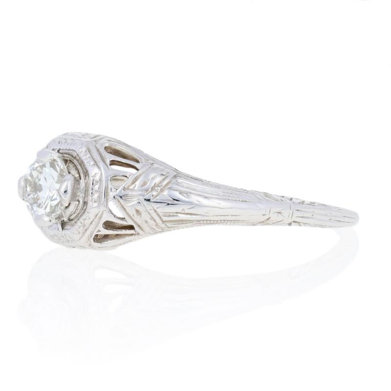 Art Deco elegance! This exquisite engagement ring from circa 1920’s-1930’s is fashioned in high purity 18k white gold and features a natural diamond solitaire. The European cut solitaire is prong-set in a raised, eight-sided bezel and ported from
