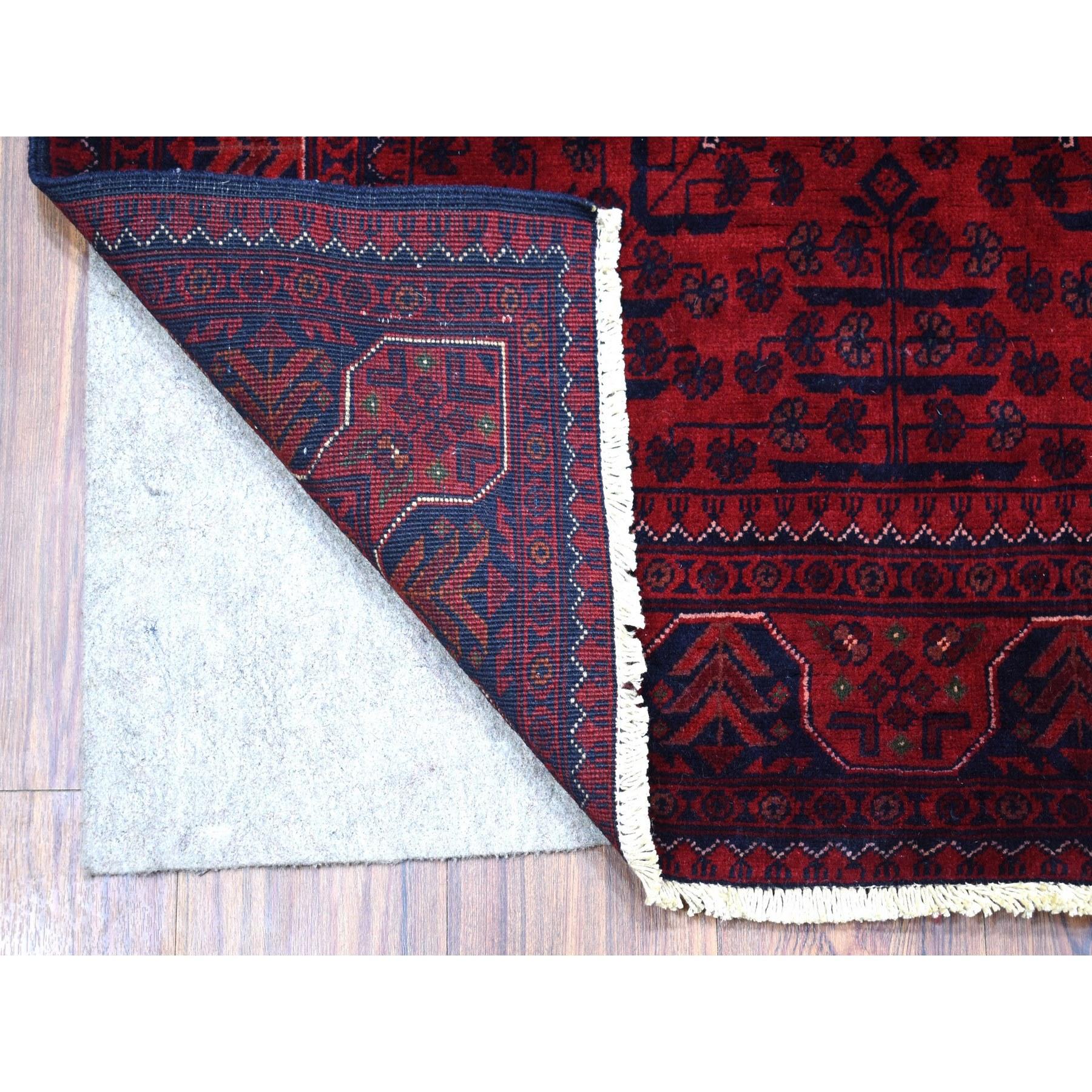 Il s'agit d'un véritable tapis d'Orient en laine biologique noué à la main, d'un rouge profond et saturé, de type Khamyab afghan à double médaillon. Il a été noué pendant des mois et des mois selon les techniques artisanales de tissage séculaires