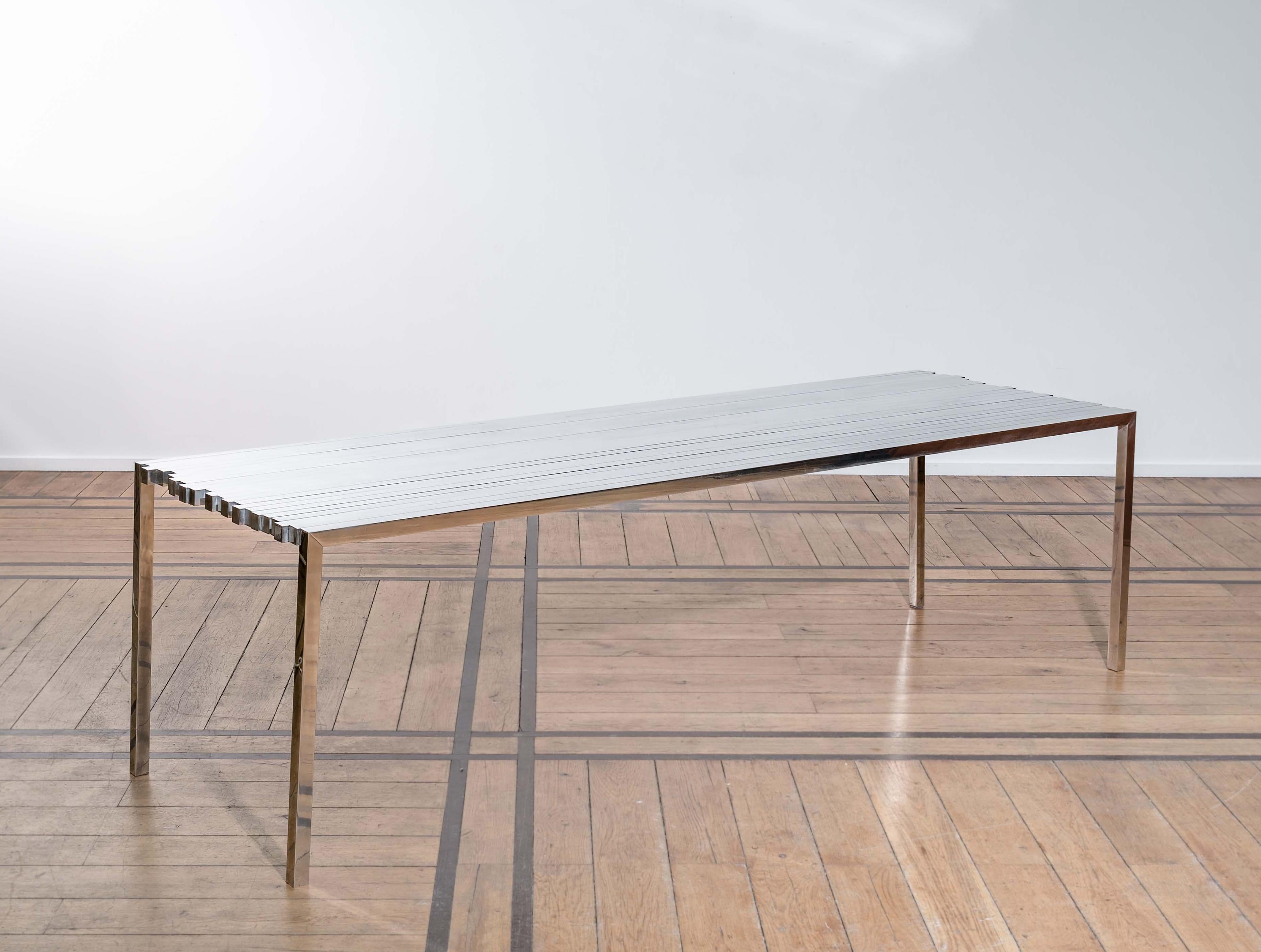 35 35 Mesa de Pol Quadens 
Edición limitada de 8+4 piezas.
Dimensiones: P 90 x An 250 x Al 74 cm.
Materiales: Aluminio pulido.

Pol Quadens nació en Bruselas. Su padre trabajaba en el campo de los materiales compuestos y la industria metalúrgica,