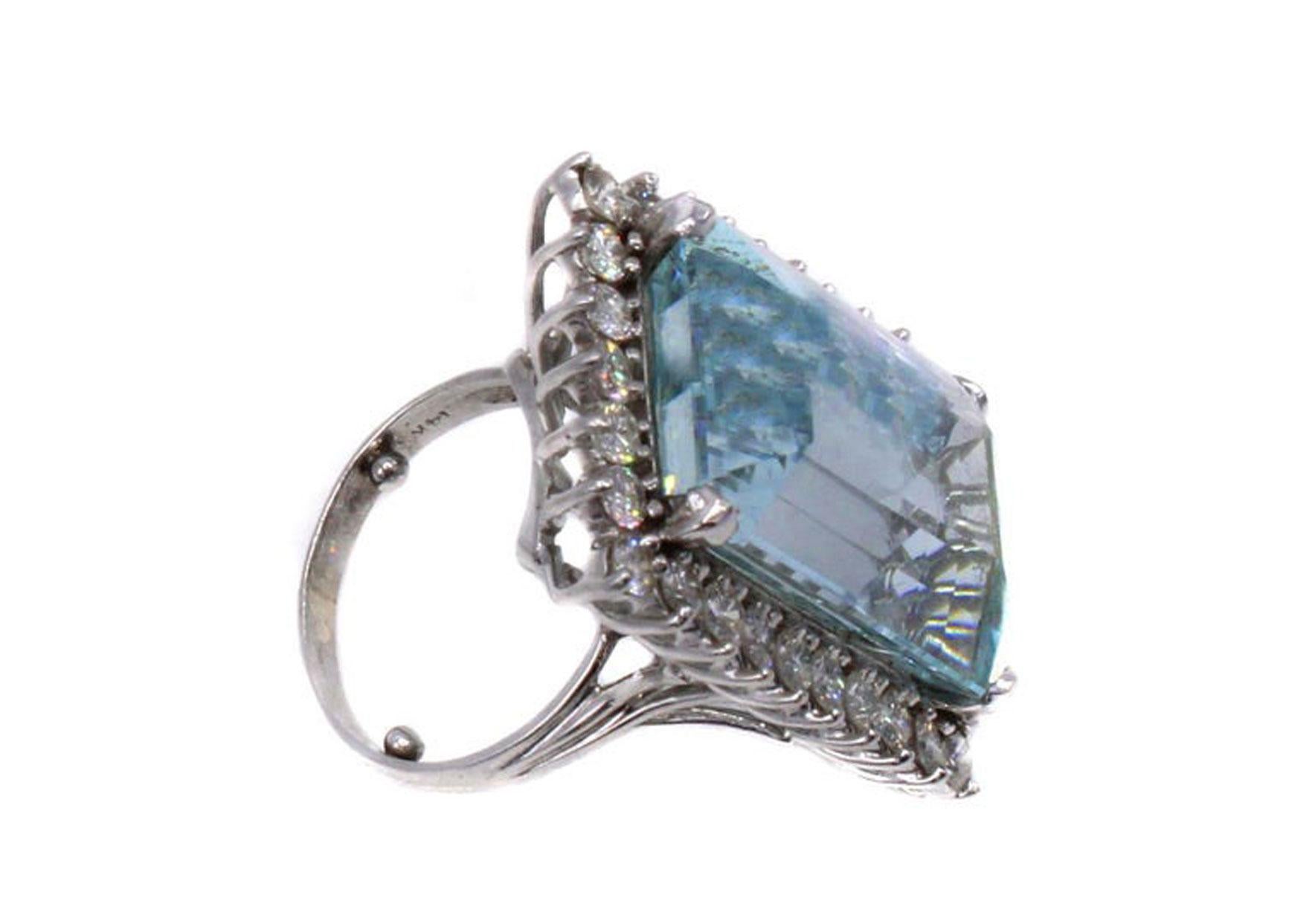 This bold 1970s ring features an elongated emerald cut Aquamarine measured to weigh approximately 35 carats. The hand-crafted platinum mounting has 30 bright white and sparkly round brilliant cut diamonds surrounding the center gem. Perfectly