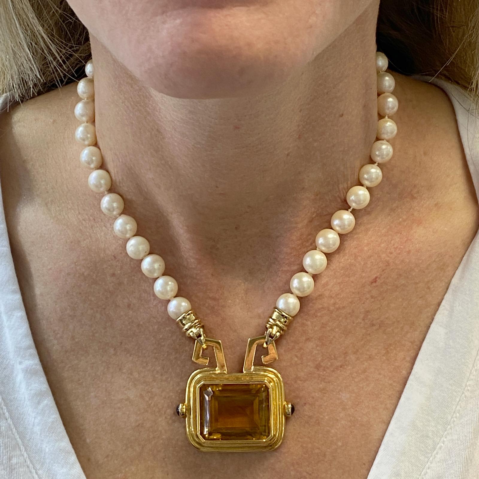 Beautiful honey citrine gemstone pendant fashioned in 18 karat yellow gold. The detachable pendant is connected to a cultured pearl necklace. The white cultured pearls measure 8-8.4mm, and the necklace measures 16 inches in length. The pendant