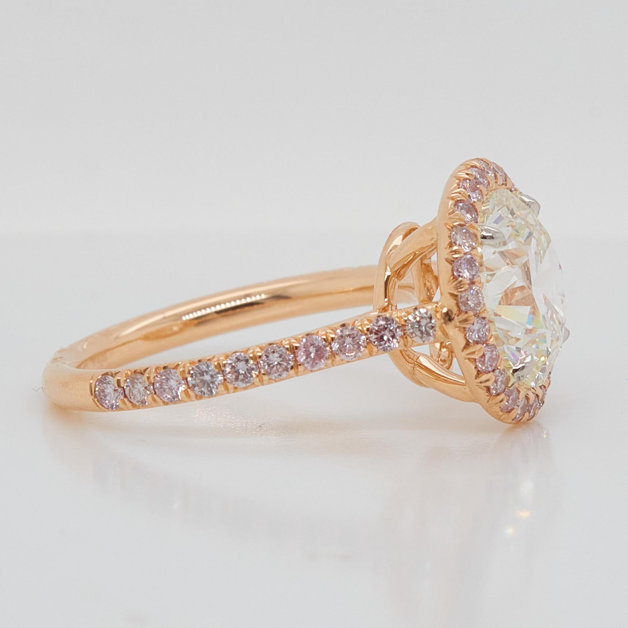 Engagement ring style showcasing a 3.5 carat cushion cut diamond certified by GIA as J color, SI1 clarity. The classic design brings out the beauty of the center stone with the surrounding 44 round pink diamonds, set in a polished 18k Rose gold