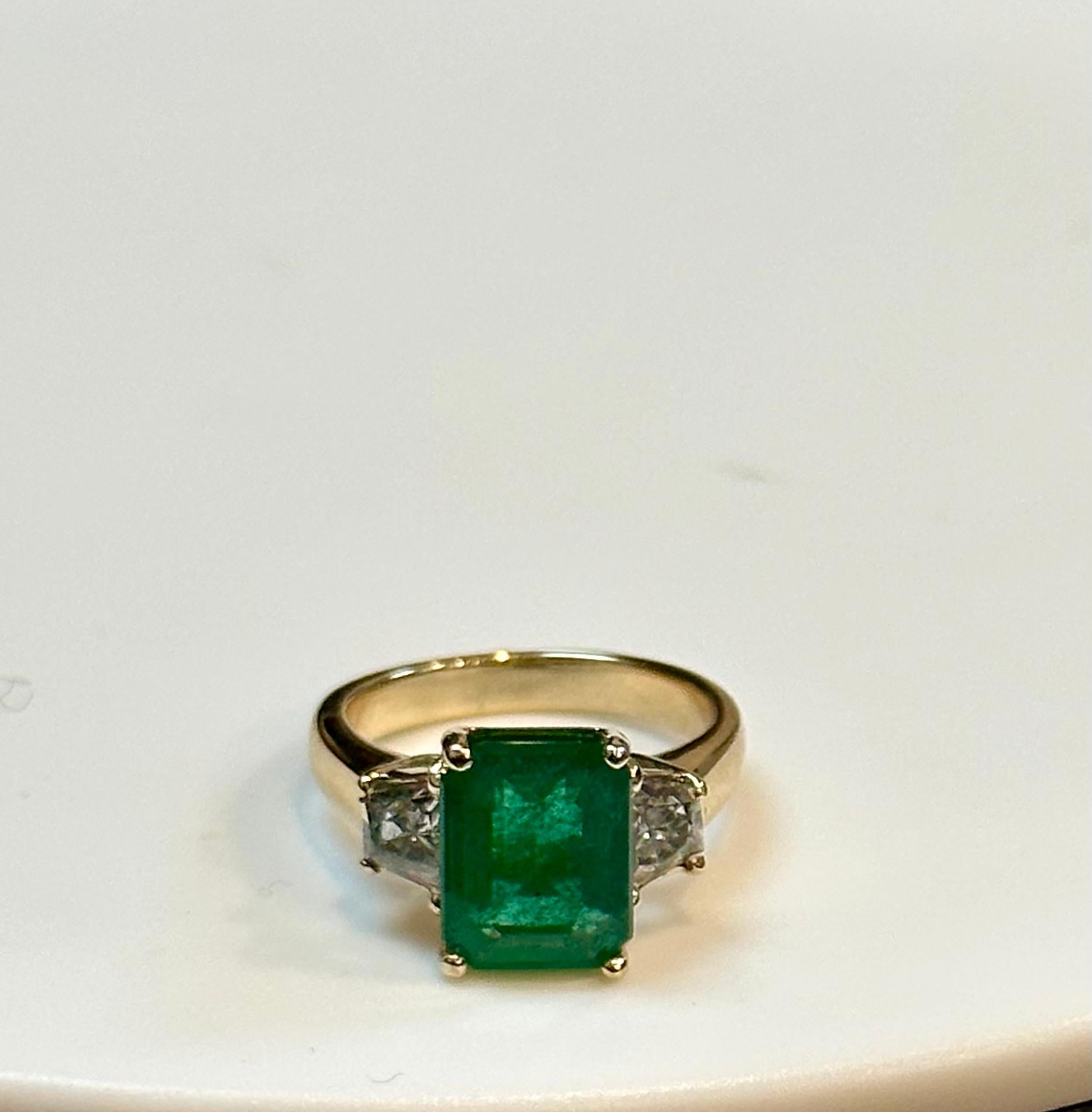 3.5 Ct Emerald Cut Colombian Emerald and 1 Carat Diamond 14 Kt Yellow Gold Ring
Estate piece Natural Emerald 
one  Trapezoid shape Diamonds on either side of the Emerald. 
14 K White gold 5.2 Gm
2 Diamonds: approximate 1 Ct Total weight 
 0.5 ct
