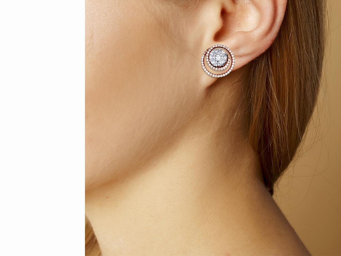 These diamond swirl earrings contain the following.  There are over one hundred and seven round brilliant diamonds that range in size from 1.2 -1.0 mm and exhibit a color and clarity of F-G VS-SI.  Each earring has  nine custom cut diamonds that