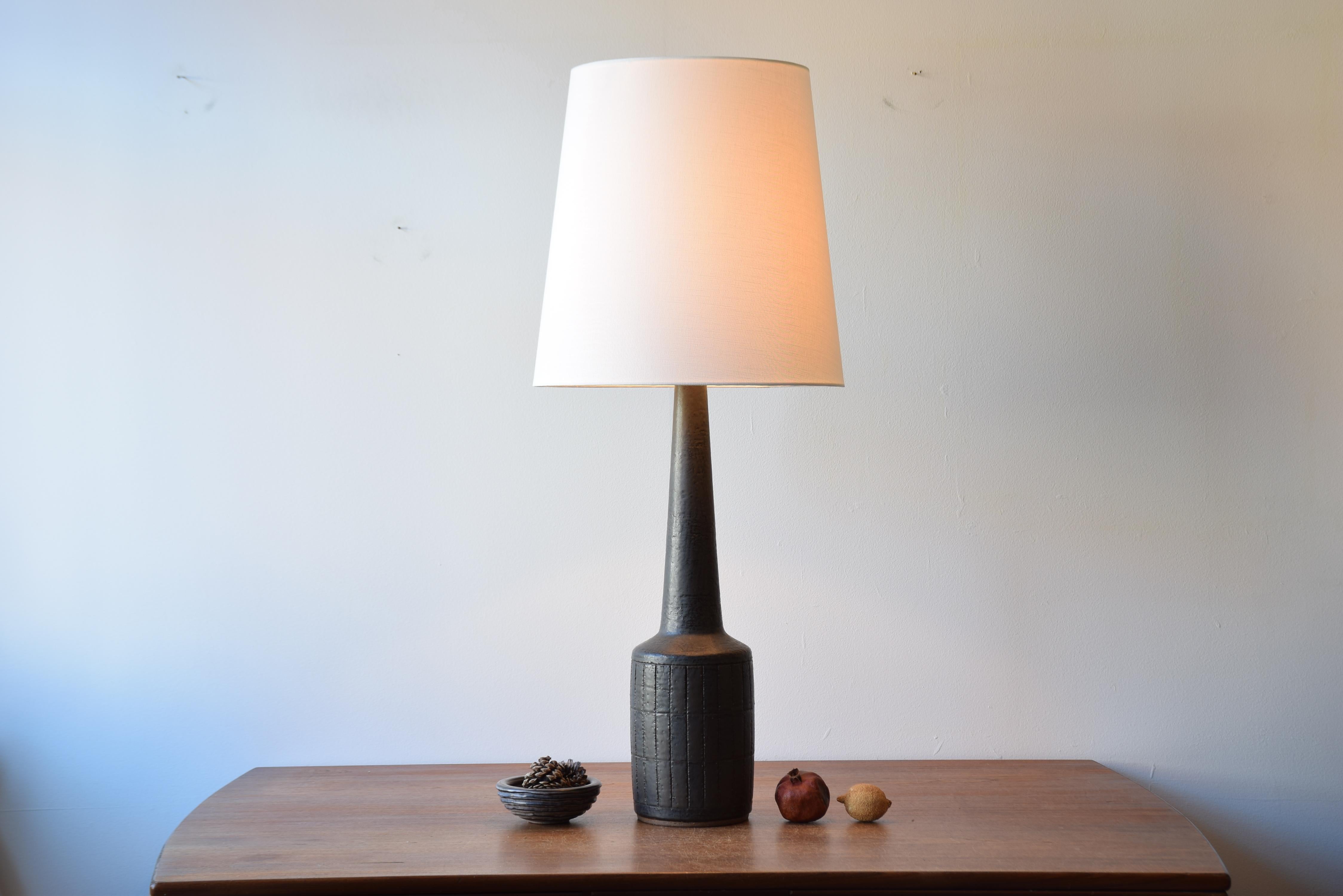Very, very tall mid-century Danish ceramic lamp designed by Per Linnemann-Schmidt for Palshus. Made circa 1960s. 

The glaze is brownish dark green and the lamp has a simple incised geometric decor. It´s made with chamotte clay which gives a tactile