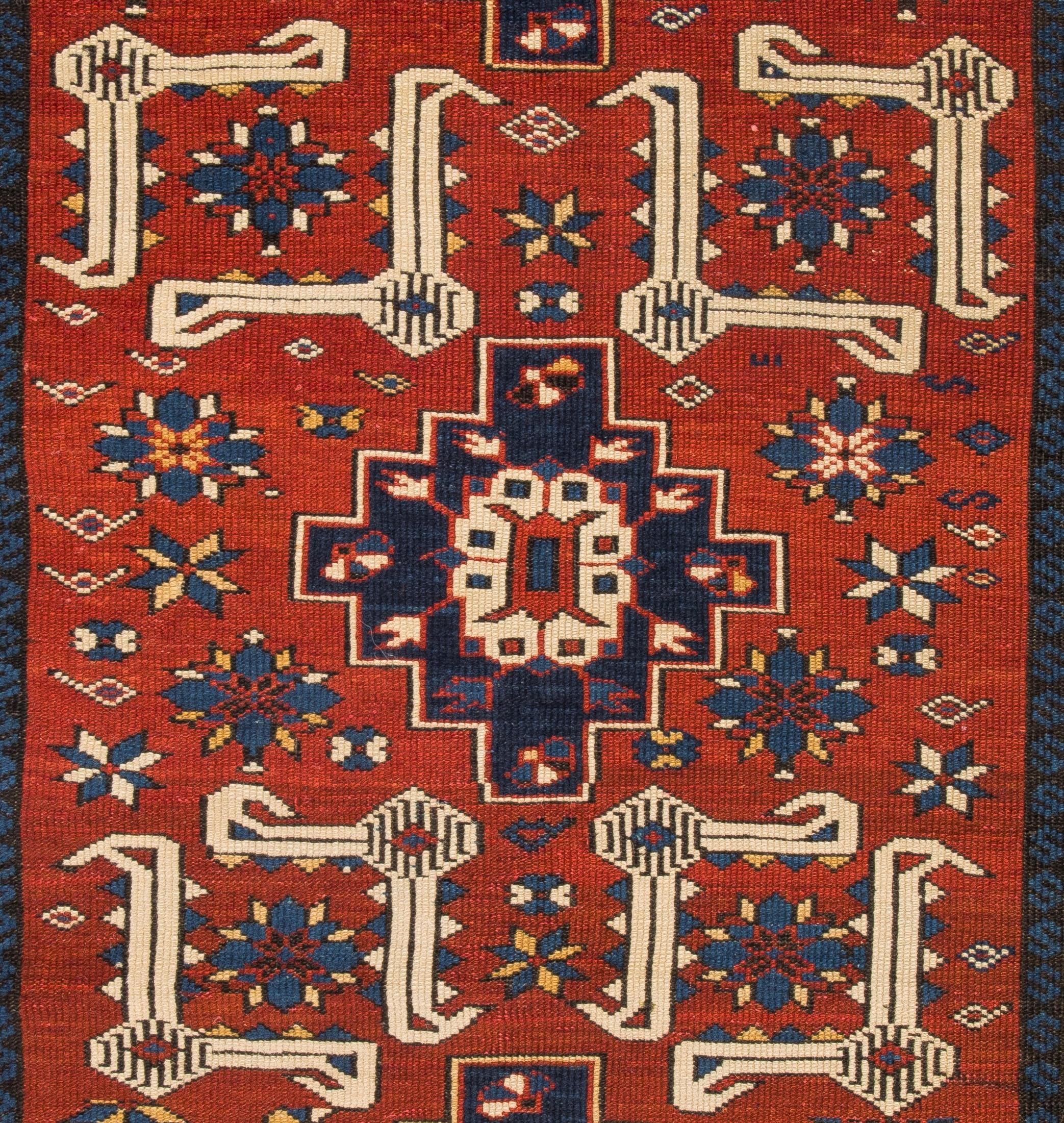 An antique Karagashli rug from the 19th century with a visually stunning and engaging design that feature multiple medallions in deep navy blue in the form of stepped diamonds that contain split palmettes with angular floral sprigs springing from