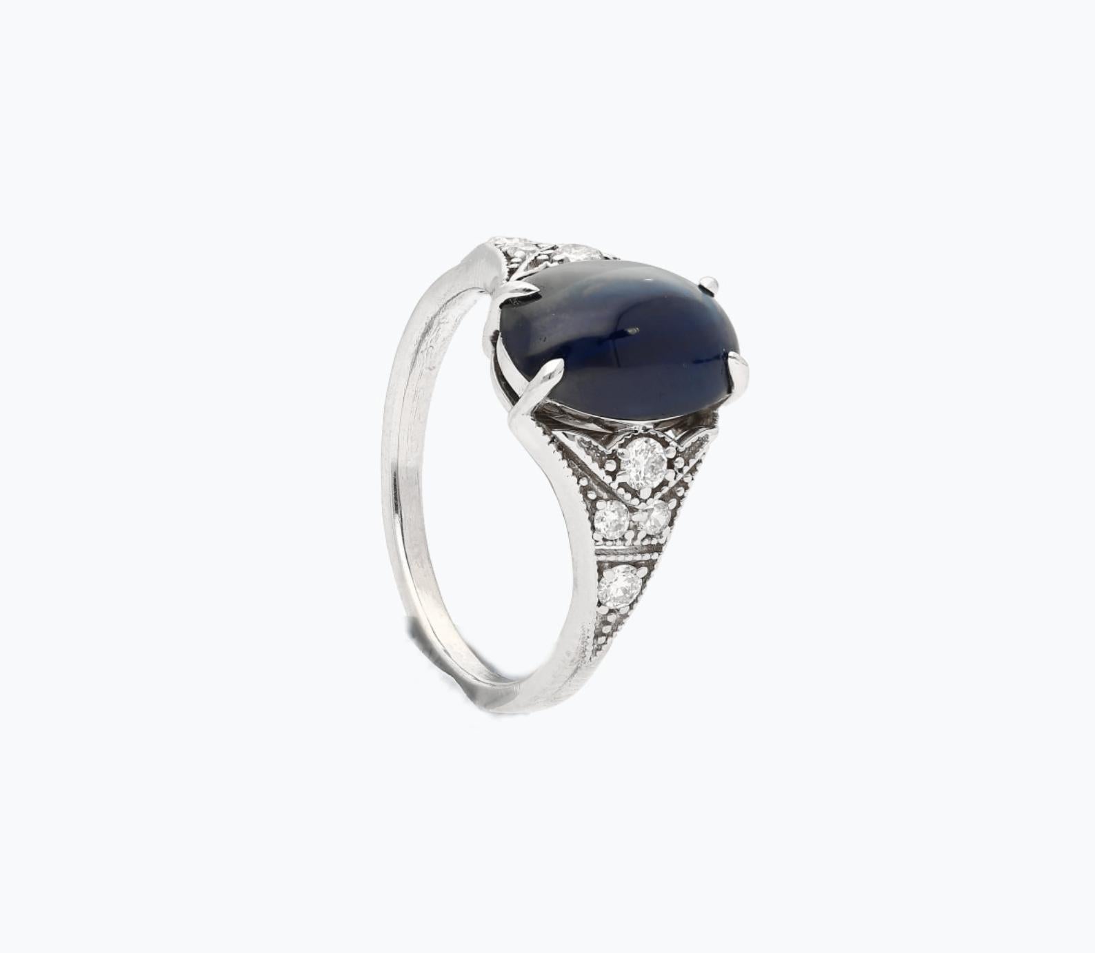 Centering a 3.50 Carat Cabochon-Cut Ceylon Sri Lanka Blue Sapphire and accented by 8 Old-Mine Cut Diamonds, this Art Deco Era Antique Jewel is a staple of the quality and beauty that made the Art Deco Era so renowned. 

Details:
✔ Gemstone: