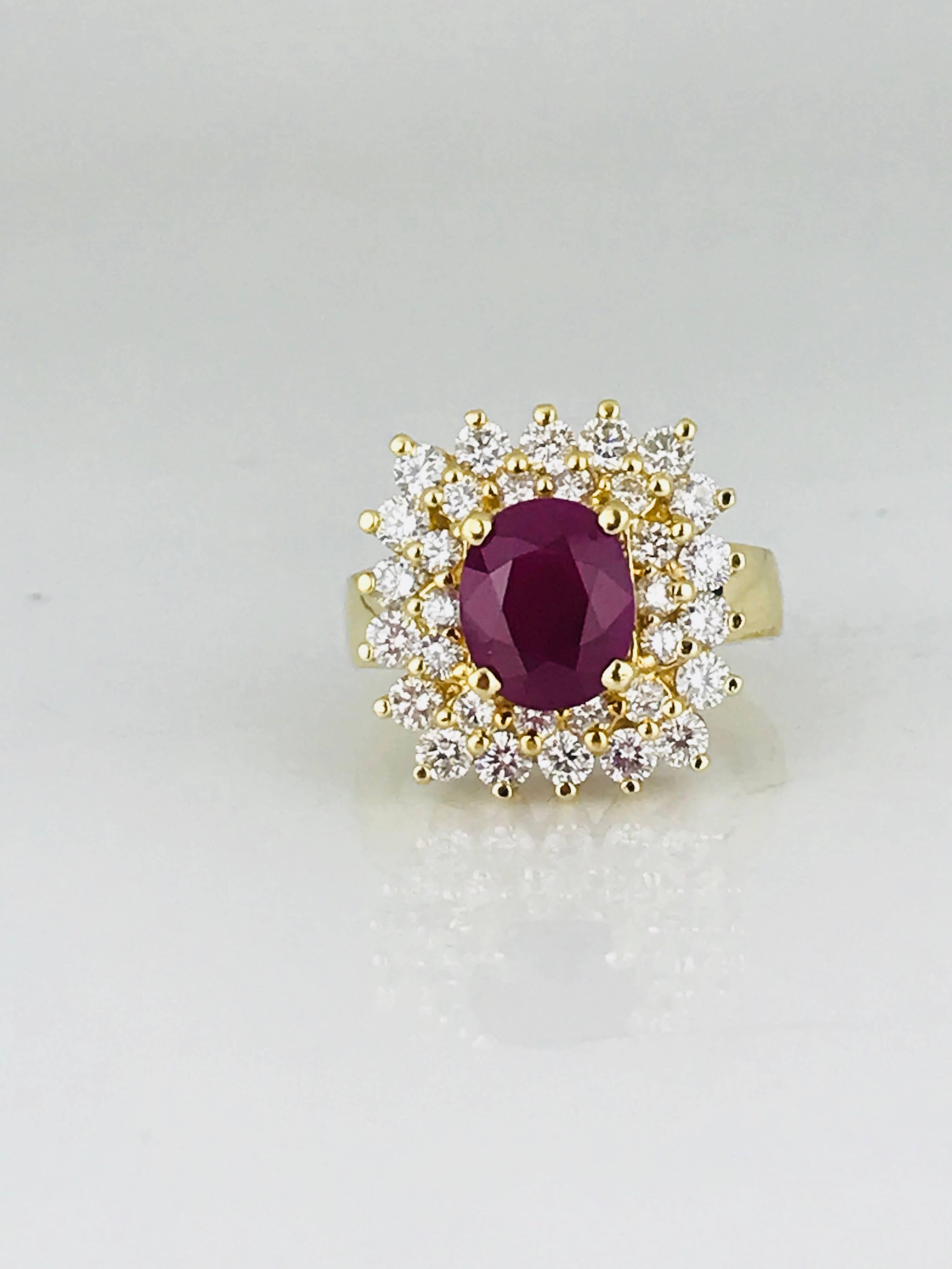 Stunning 18 karat yellow gold ring features an oval-cut, prong-set red Burmese ruby surrounded by a double halo of (32) shared-prong set round brilliant diamonds for a squared effect.

Oval Burmese ruby measures 9.52 mm x 7.46 mm x 5.79 mm and
