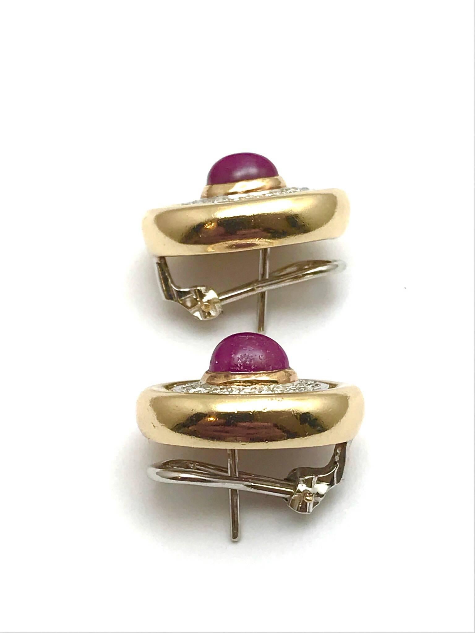A pair of 3.50 carats cabochon ruby and round diamonds 14 karat white and yellow gold clip and post earrings.  The rubies are bezel set in yellow gold, with a single row of round diamonds in white gold surrounding, framed in by a yellow gold border.