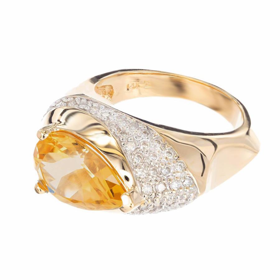 Anello cocktail in oro giallo e bianco 14k con citrino e diamante. Citrino a forma di pera incastonato in un anello a cupola alta in orizzontale con un'ampia fascia di diamanti incastonati dal punto di avvolgimento in giù e dietro la curva del