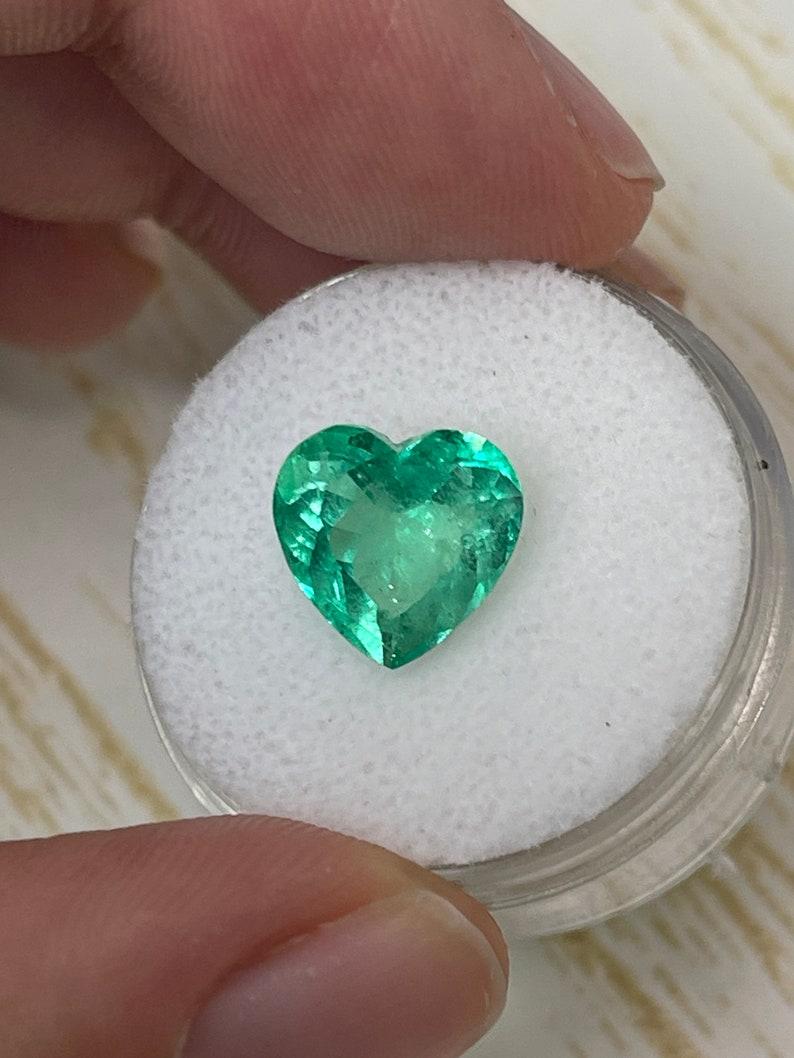 Stone: Emerald
Weight: 3.50 carats
Shape: Heart Cut
Clarity: Transparent
Luster: Very Good
Color: Medium Light Yellowish Green
Measurements: 10.21mm x 10.51mm x 6.35mm
Geographic Origin: Colombia
Treatment: Natural, Oiling

Comments: Due to their