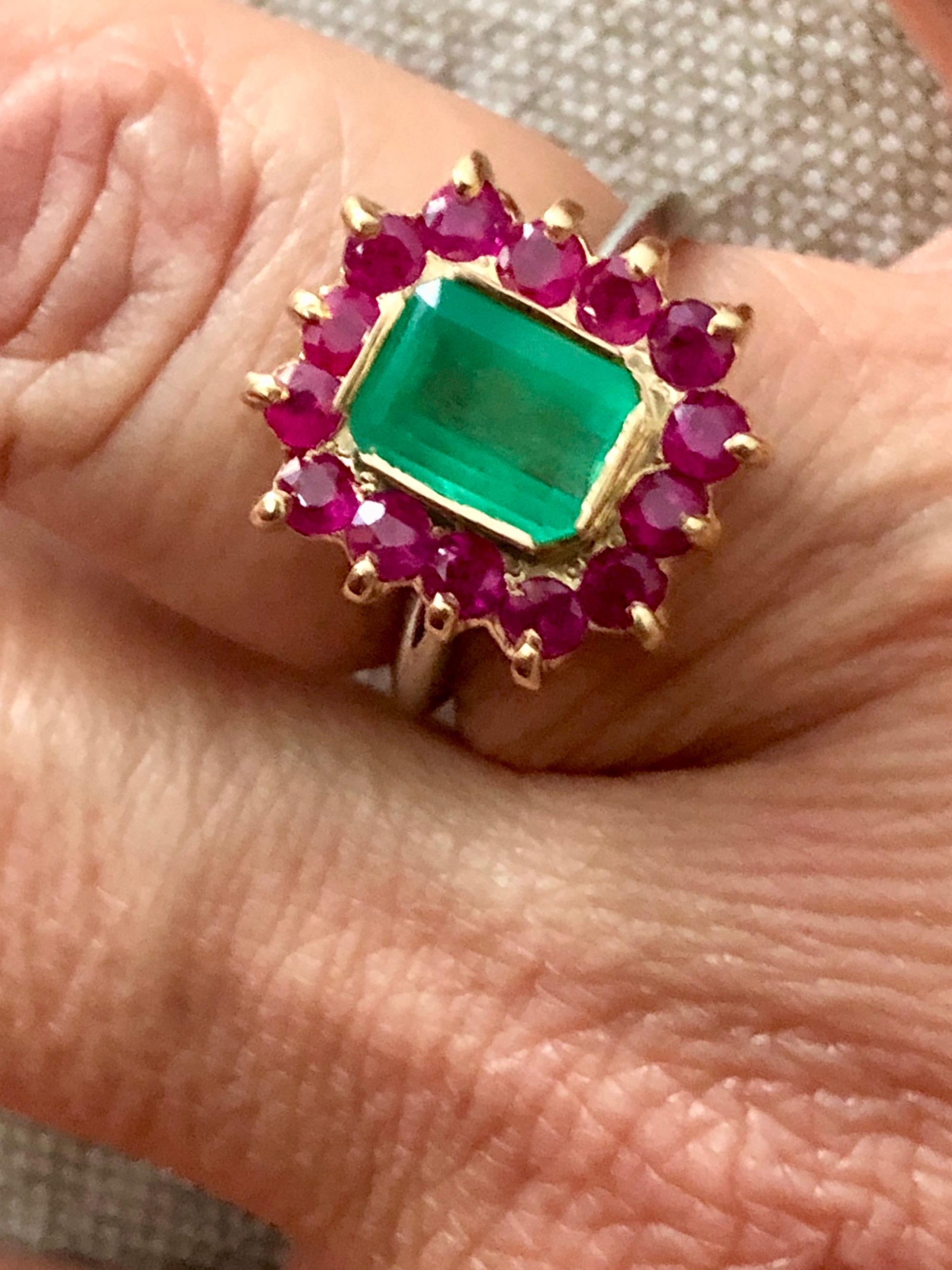 3.50 carat Vintage emerald, ruby ring, set in the center with a natural Colombian emerald measuring approximately 7.7mmx5.8mm., weighing approximately 1.40 carats, framed by 15 round rubies weighing approximately 2.10 carats. 
The 18K yellow gold