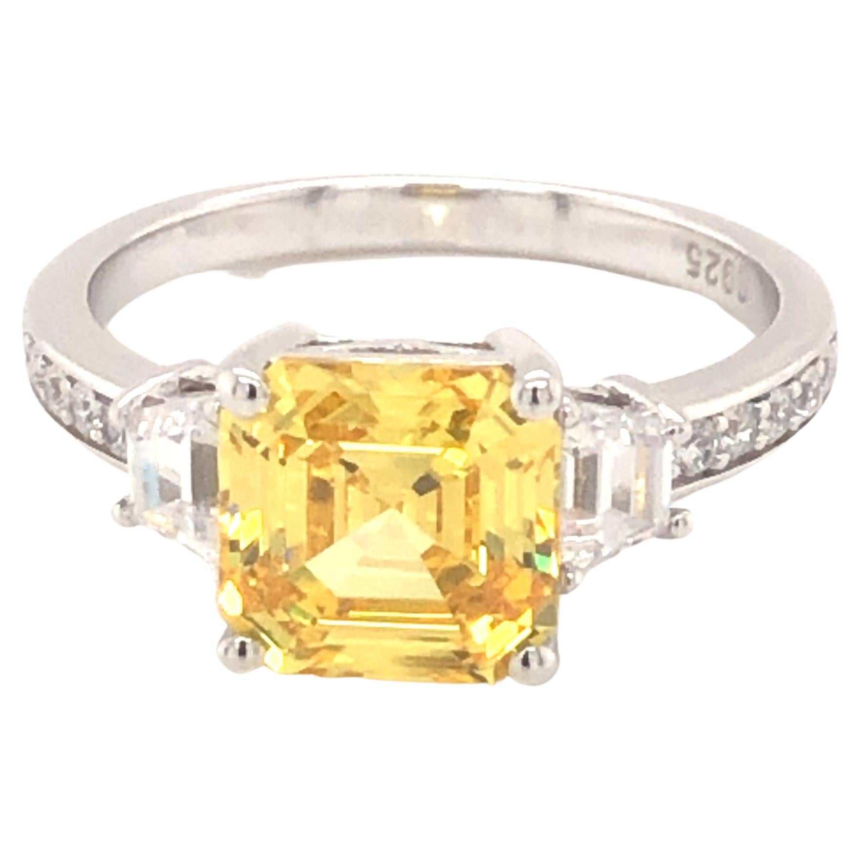 Glorious sunshine hues radiate from this elegant and classic ring. Featuring a dazzling 3.50ct centre asscher cut cubic zirconia flanked by two tapered princess cuts with five round brilliant cuts on either side. 

Composed of 925 sterling silver