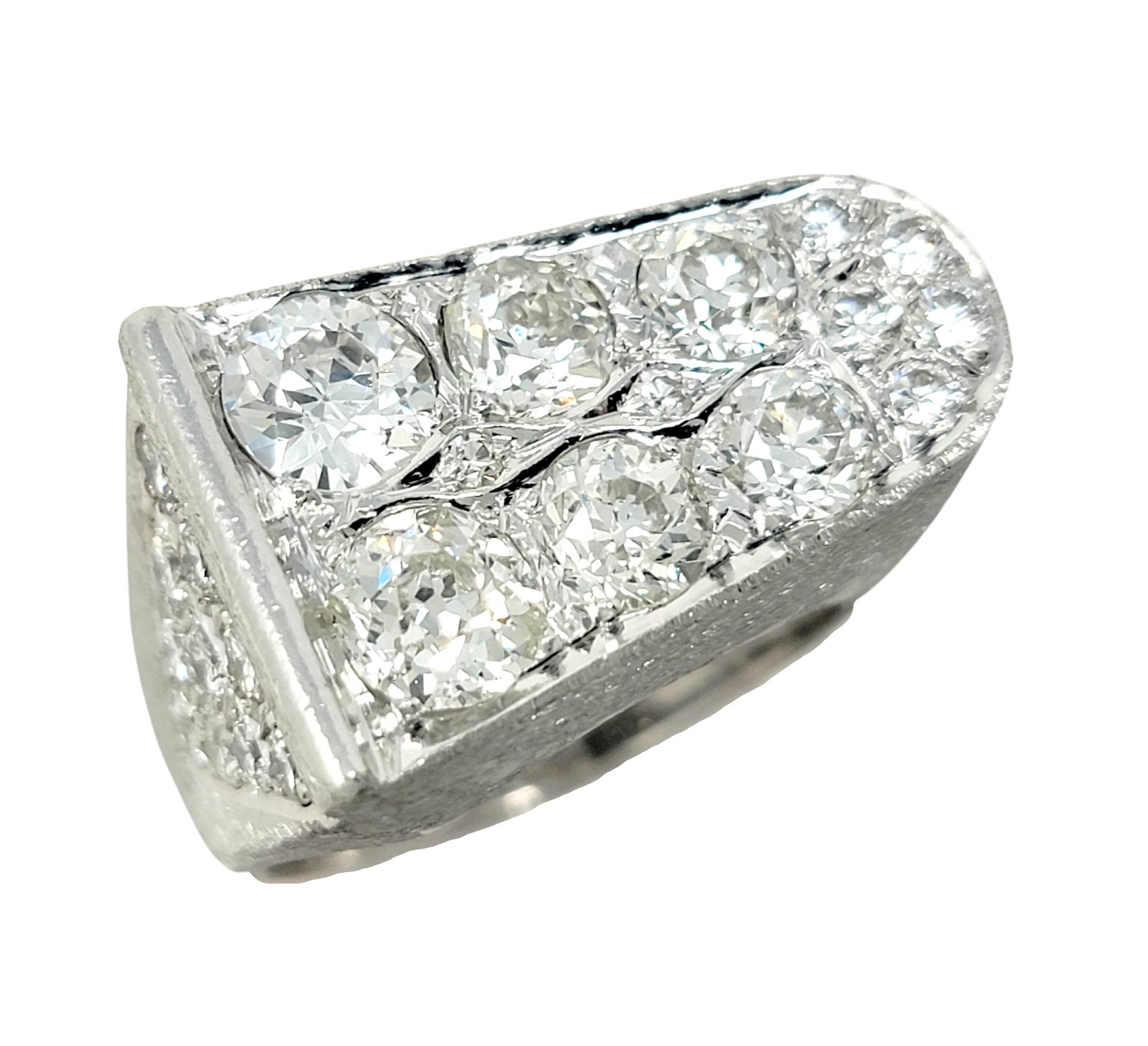 Ring size: 8.5

Bold and brilliant mens diamond band ring. This incredible piece features a sleek, contemporary style with an asymmetrical design. Six incredible, icy white Old European cut diamonds decorate the top of the piece, while additional