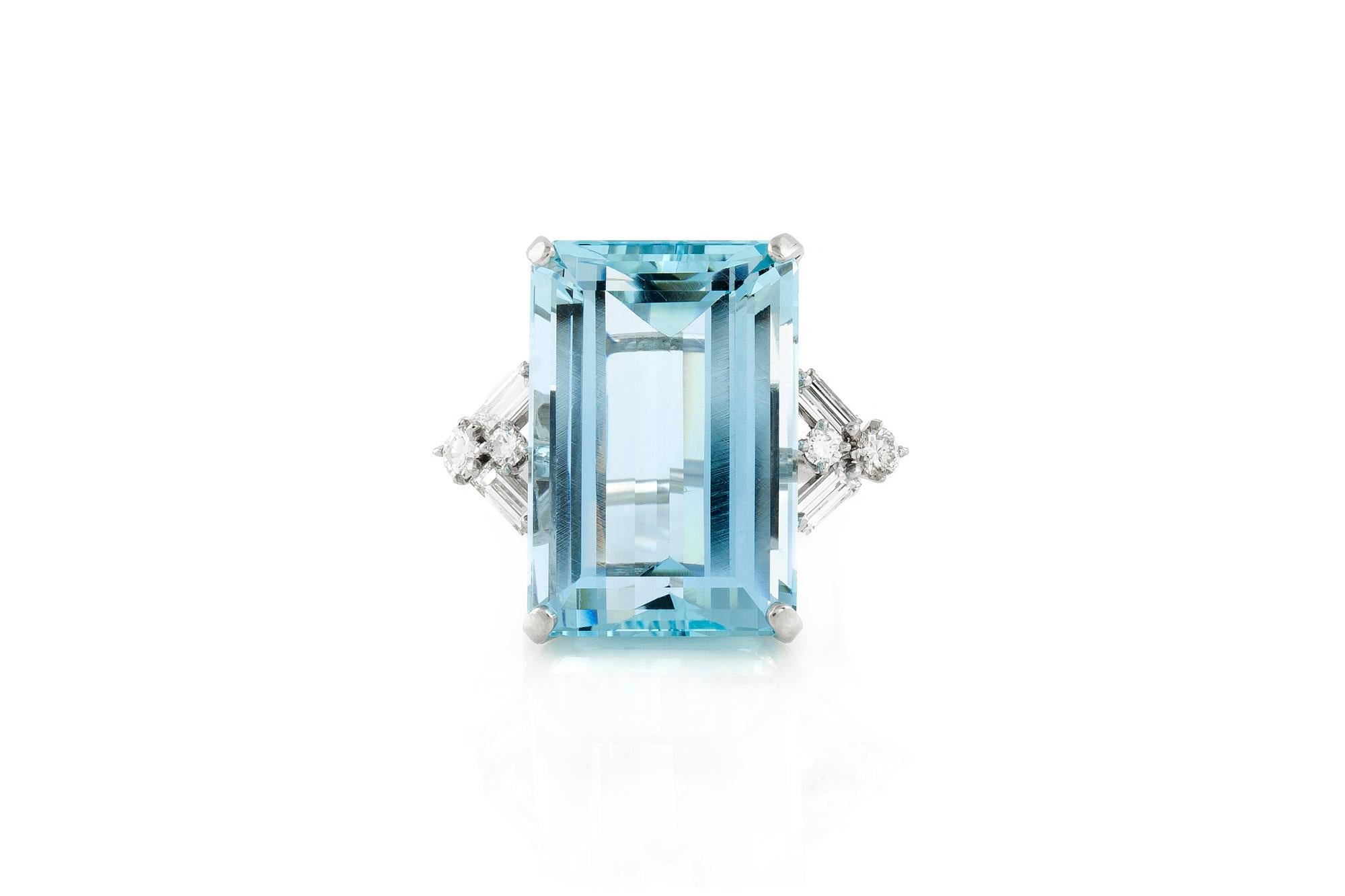 Vintage Art Deco ring, finely crafted in platinum with emerald cut Aquamarine at the center, weighing approximately 35.00 carat. The center stone is flanked by baguette and round brilliant cut diamonds, weighing a total of approximetaly 1.00 carat.