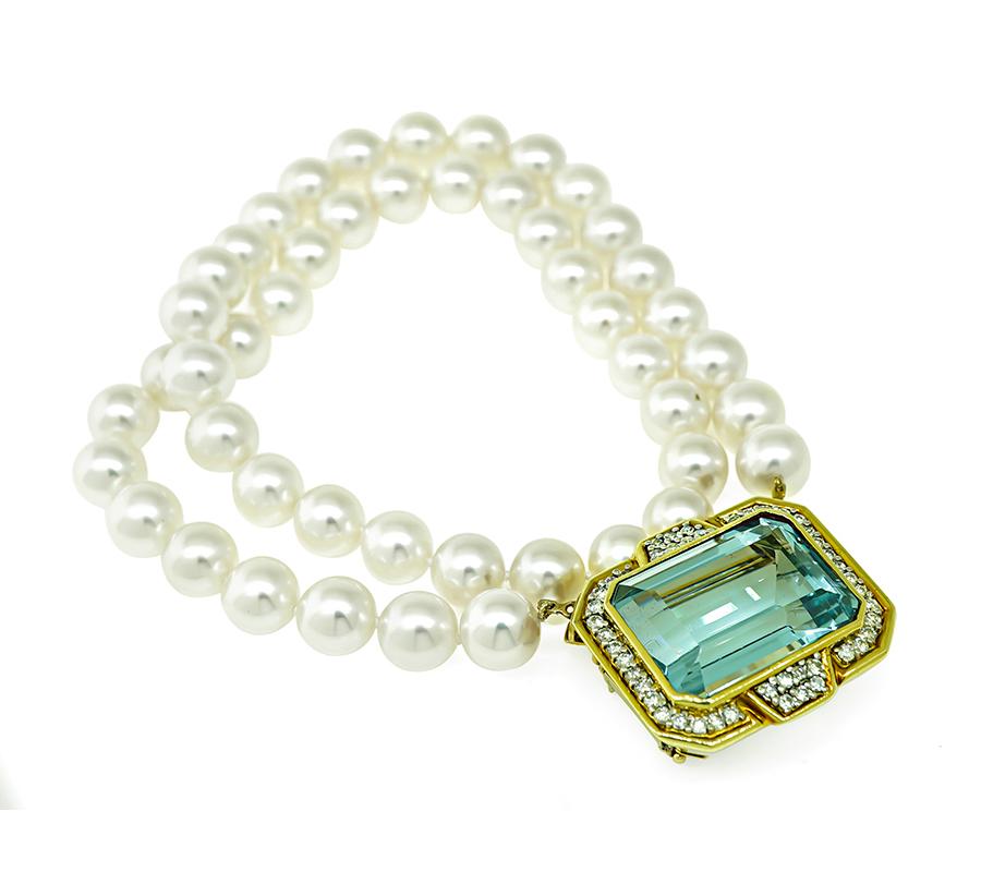 This is a gorgeous 18k yellow gold pearl pin / pendant necklace. The necklace is centered with a lovely emerald cut aquamarine that weighs approximately 35.00ct. The center stone is accentuated by sparkling round cut diamonds that weigh