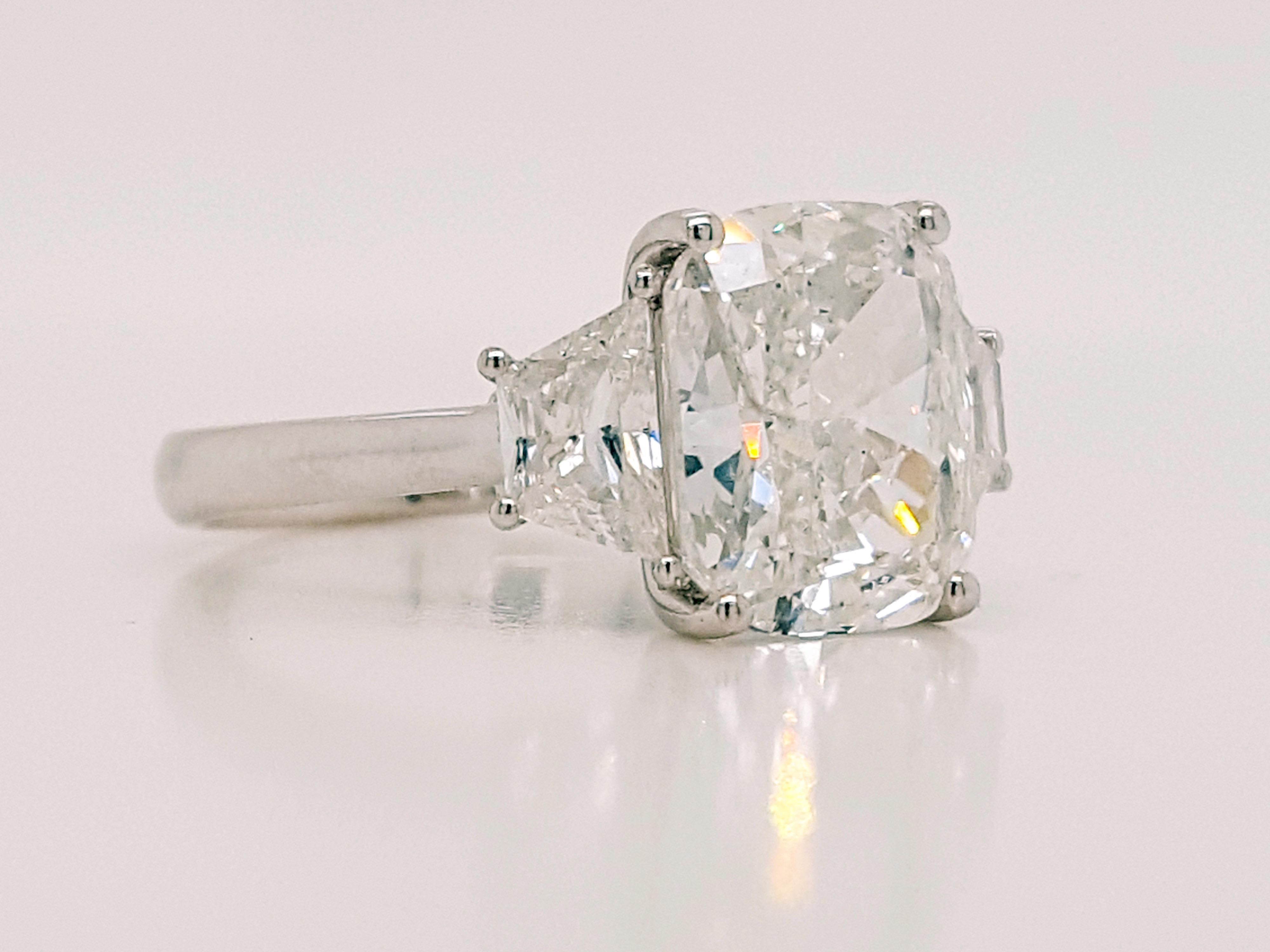 This stunning Three-Stone style engagement ring showcasing a 3.50 carat Cushion cut Natural diamond certified by GIA as G color, SI2 clarity. Flanked by two Cadillac cut diamonds total weight 0.90 carat. Set in polished 18K white gold. 

The total