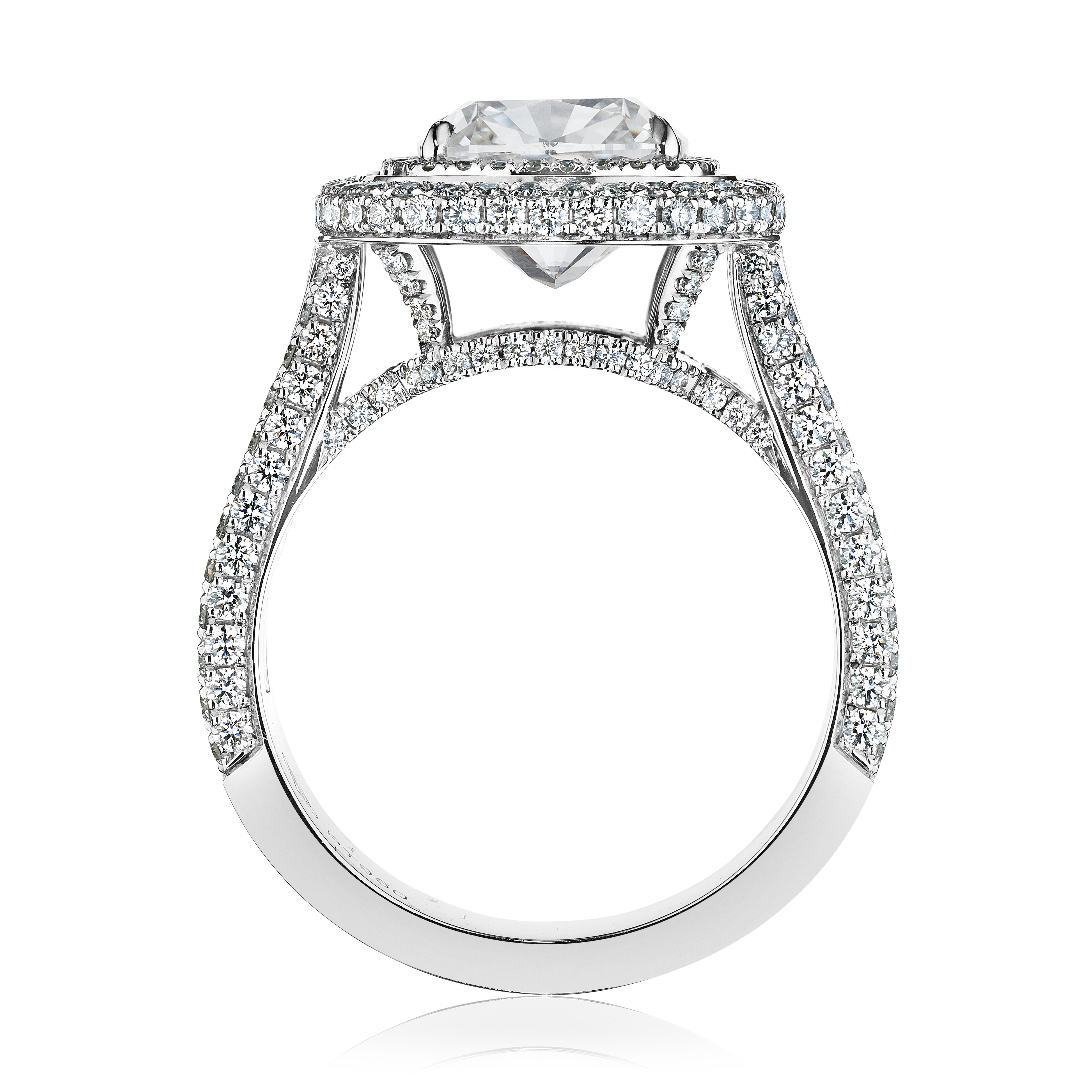 Unveil the splendor of bespoke elegance with this custom-made platinum engagement ring, featuring a majestic 3.5ct cushion-cut center stone. The centerpiece, a diamond of unparalleled clarity and mesmerizing depth, is cradled within a secure
