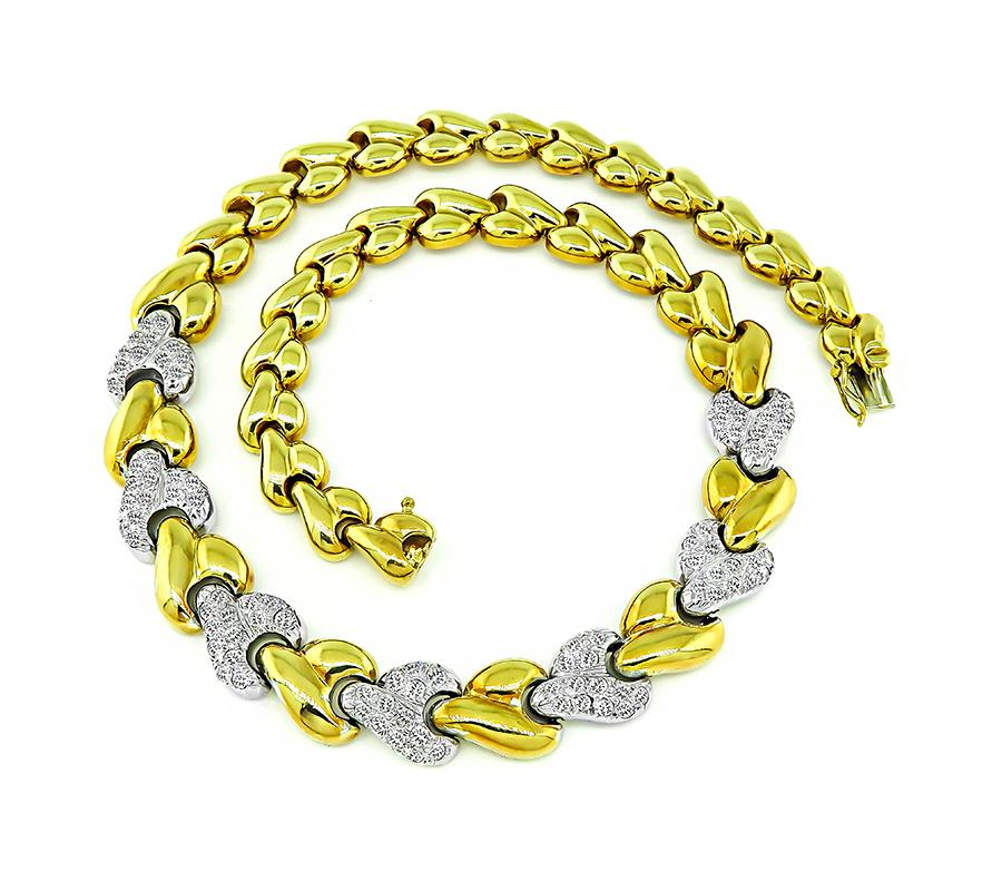 This is a charming two tone 18k yellow and white gold necklace. The necklace is set with sparkling round cut diamonds that weigh approximately 3.00ct. The color of these diamonds is G-H with VS clarity. The necklace has a tapering width from 9mm to