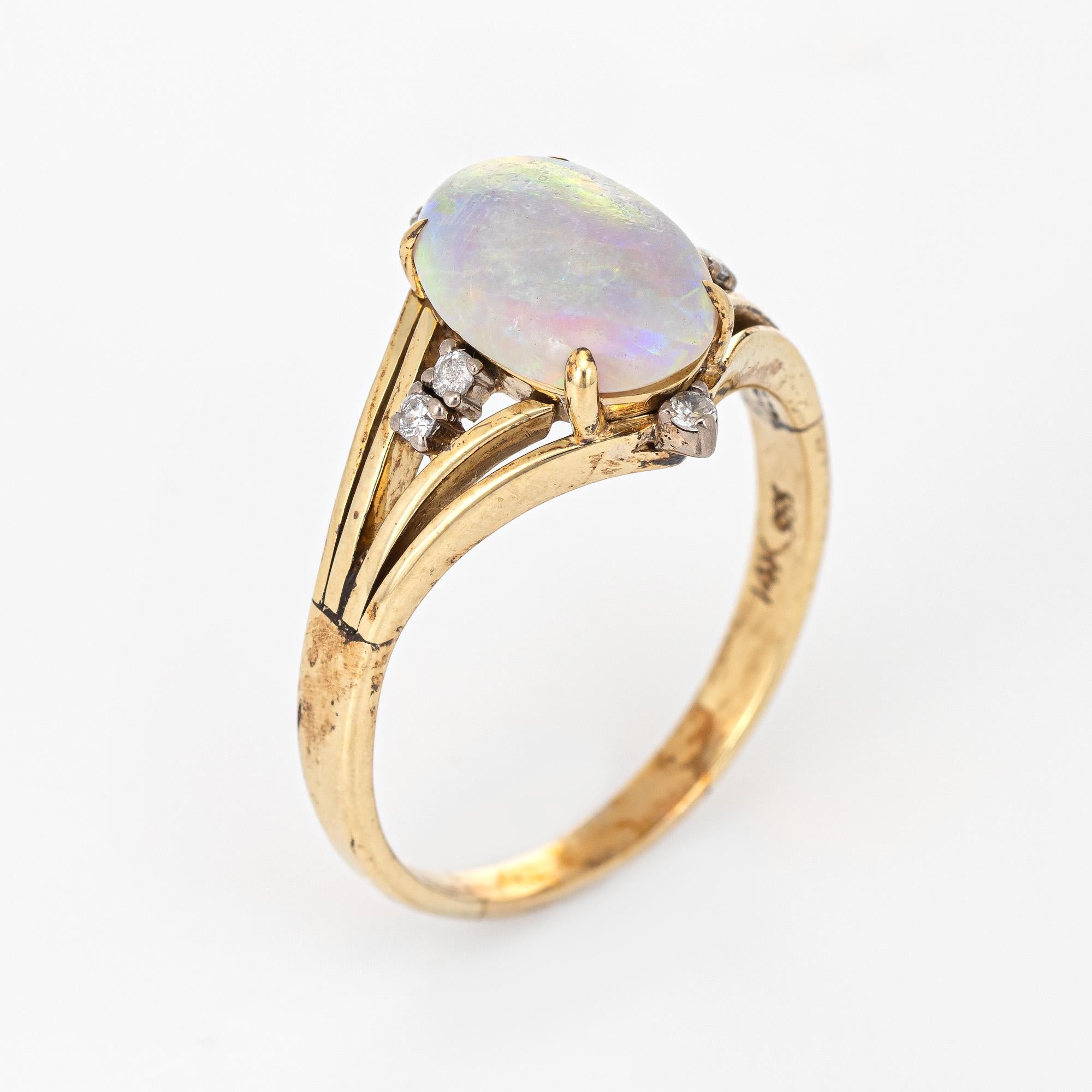 Stylish vintage natural opal cocktail ring (circa 1970s) crafted in 14 karat yellow gold. 

Cabochon cut natural opal measures 12mm x 8mm (estimated at 3.50 carats) is accented with an estimated 0.06 carats of diamonds (estimated at J-K color and I2