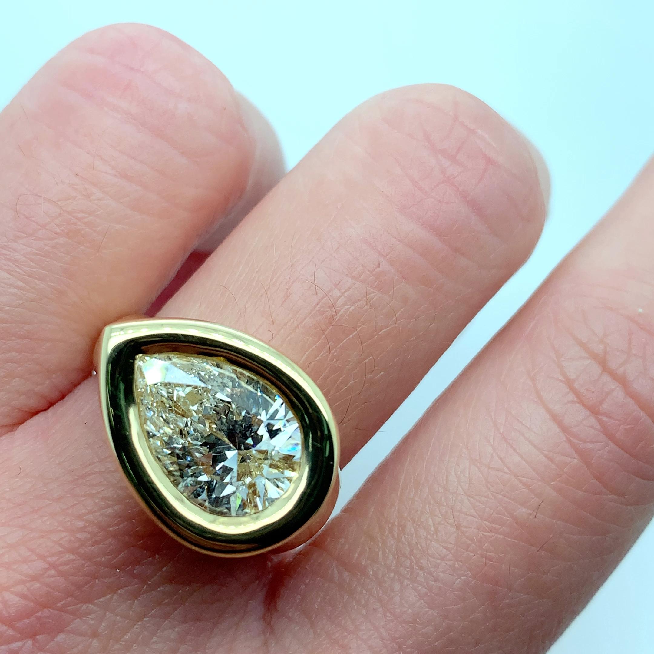 This stunning ring is a must-have for anyone who loves fine chunky jewellery. The 3.50ct pear shaped diamond bezel set chunky cocktail ring is made from 18k yellow gold, and features a beautiful pear-shaped solitaire main stone. The ring is designed