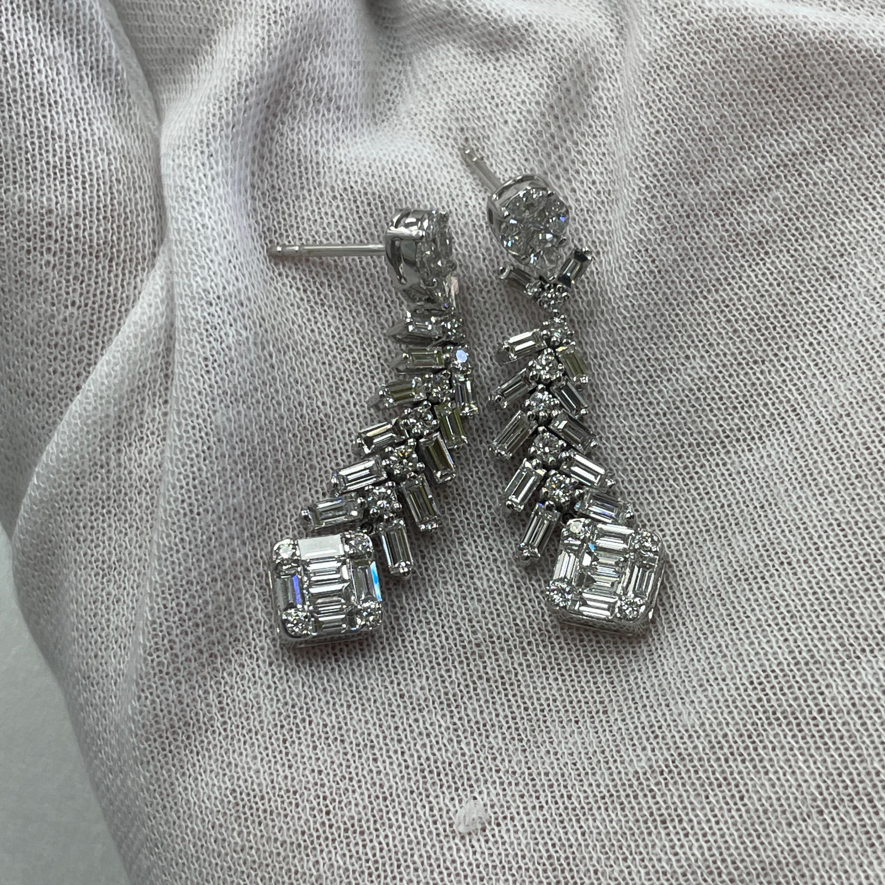 These elegant 18K white gold dangling earrings carry 3.52Ct of brilliant white diamonds