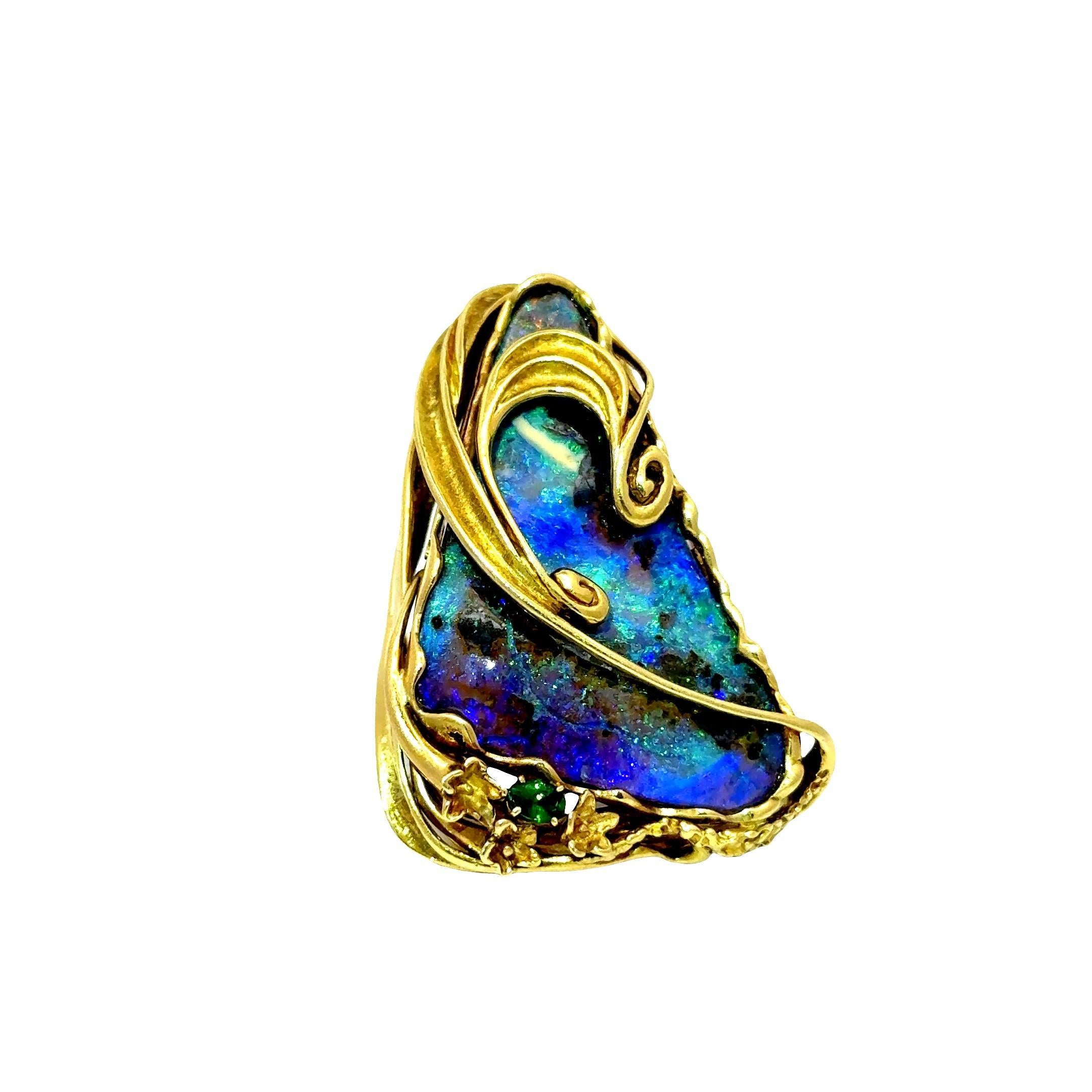 A captivating opal, weighing 32.23 carats, forms the centerpiece of this contemporary ring. The opal's smooth and lustrous surface showcases a mesmerizing rainbow of colors. Accentuating the opal is a 0.18-carat tsavorite, cut in an oval shape,
