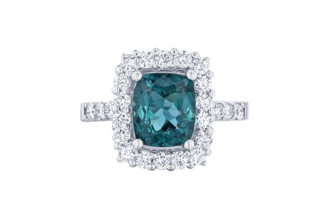 This ring has a 2.63 carat Apatite in the center of the ring and is surrounded by a halo of 24 Round Cut Diamonds that weigh 0.90 carat. The total carat weight of the ring is 3.53 carats.  

The ring is made in 14K White Gold and weighs