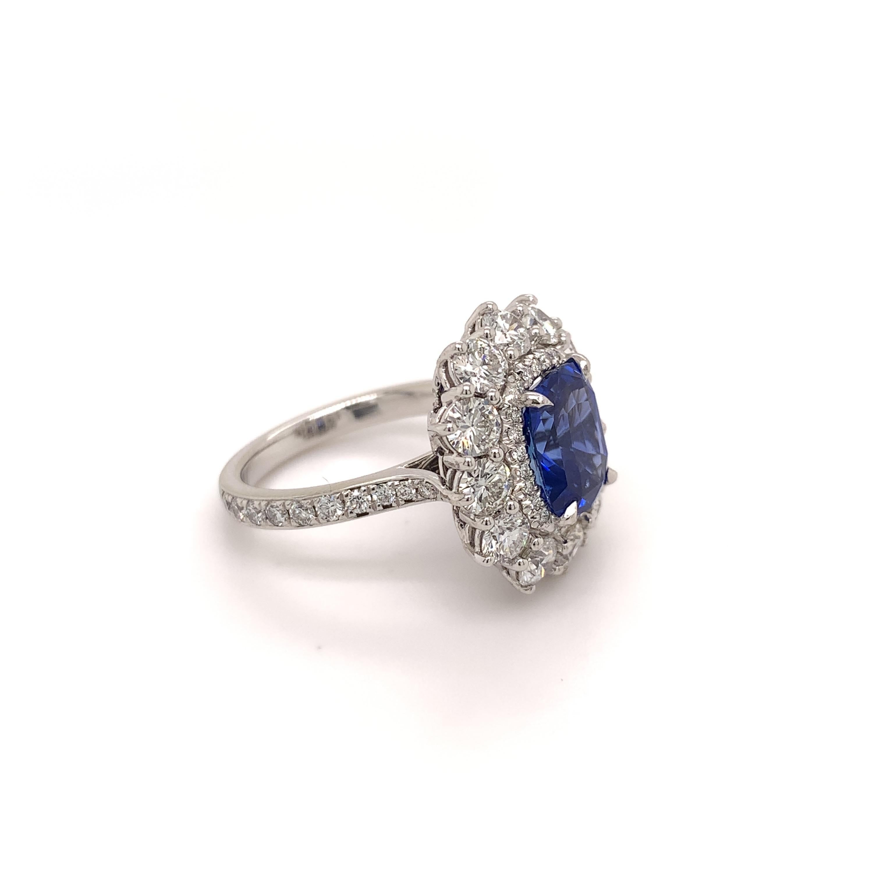 Glamorous sapphire diamond ring. High brilliance, violetish blue, cushion faceted natural 3.53 carats sapphire encased in basket mounting with four knife prongs, accented with two rows of round brilliant cut diamonds. Beautiful handcrafted