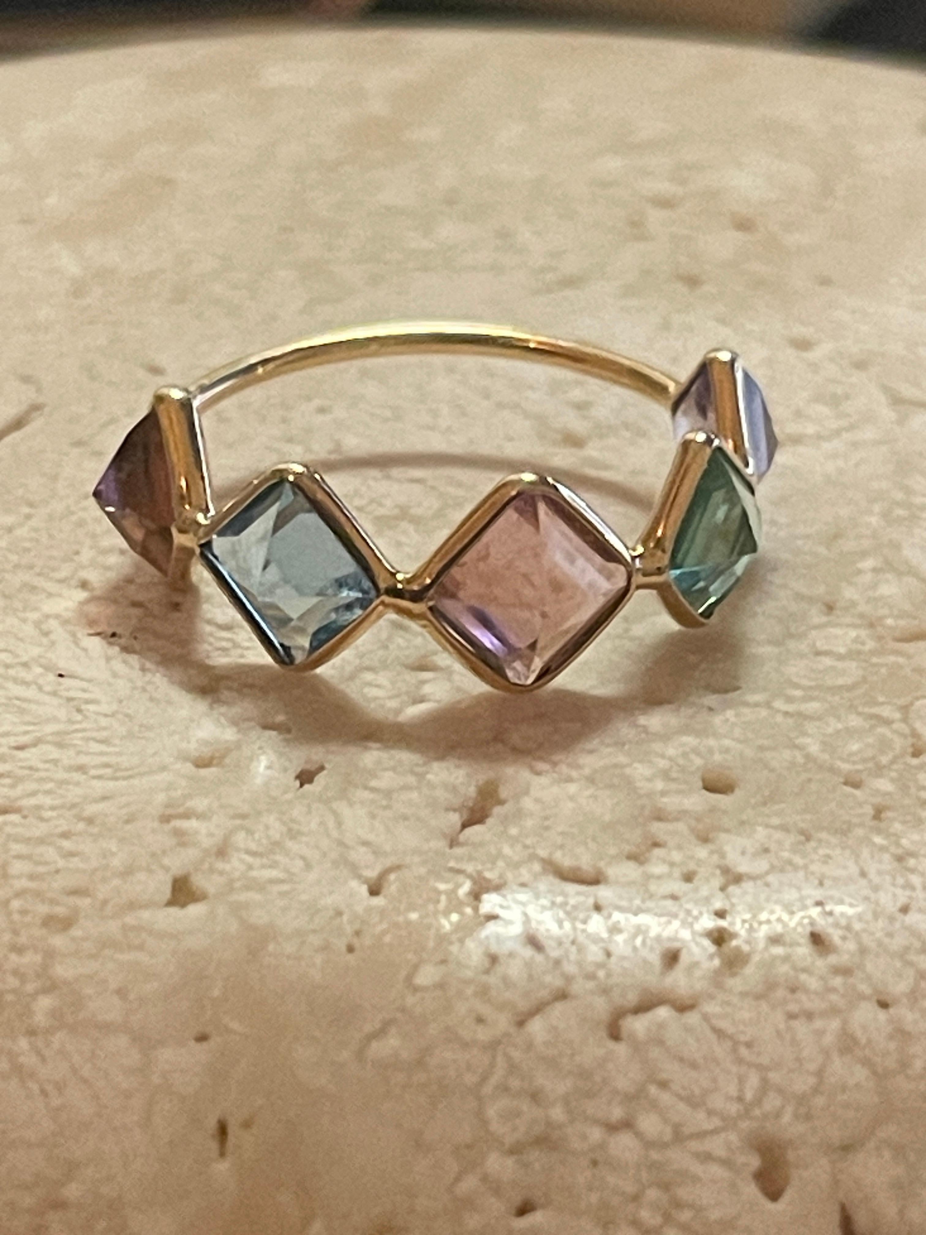This beautiful 18K Gold ring is comprised of 5 emerald cut gemstones including Green Tourmaline, Pink Tourmaline, Watermelon Tourmaline, Amethyst & Aquamarine. Each gemstone is emerald cut and set upside down giving the top of the ring a peak for