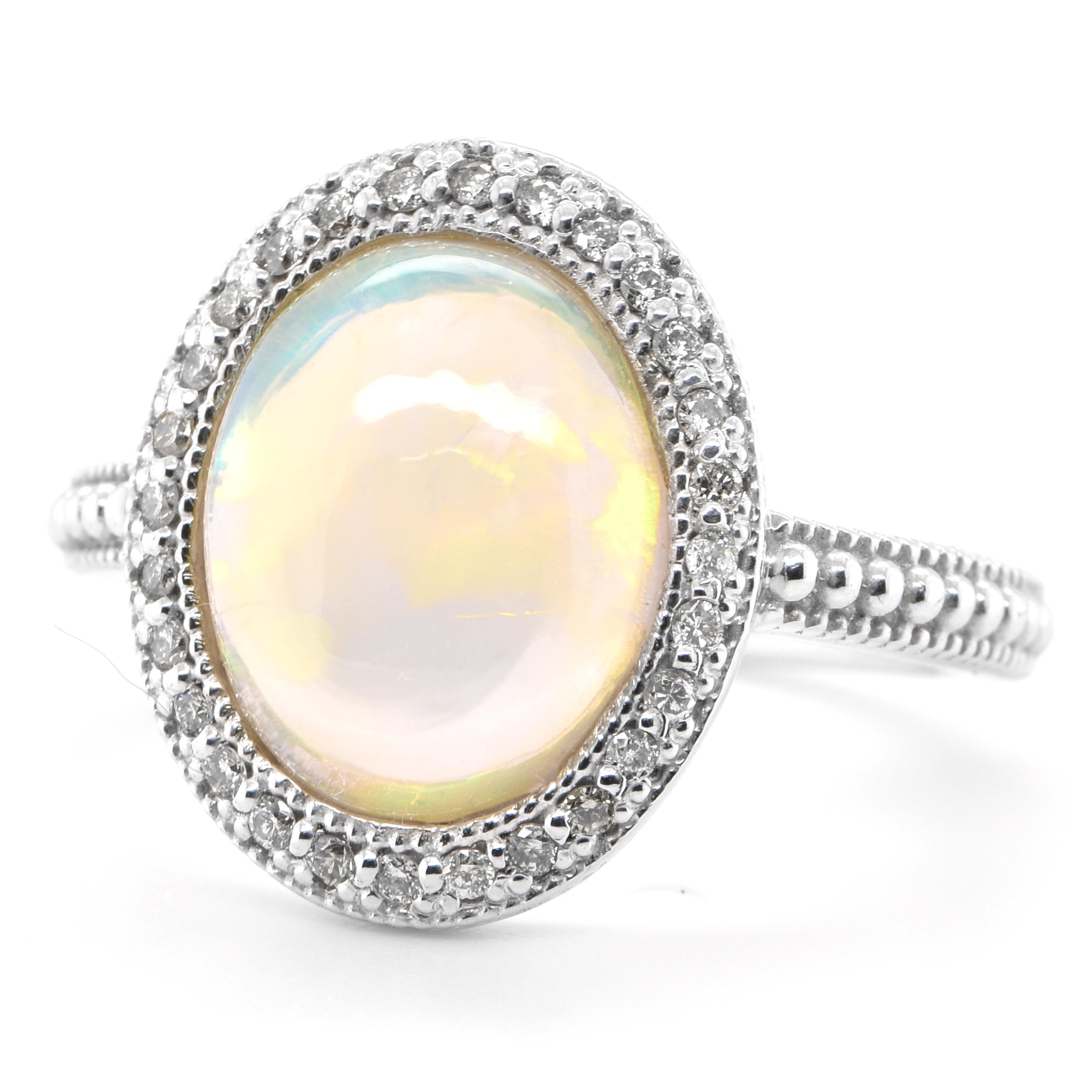 A beautiful vintage ring featuring a 3.54 Carat Natural, White Opal and 0.23 Carats of Diamond Accents set in 18K White Gold. Opals are known for exhibiting flashes of rainbow colors known as 