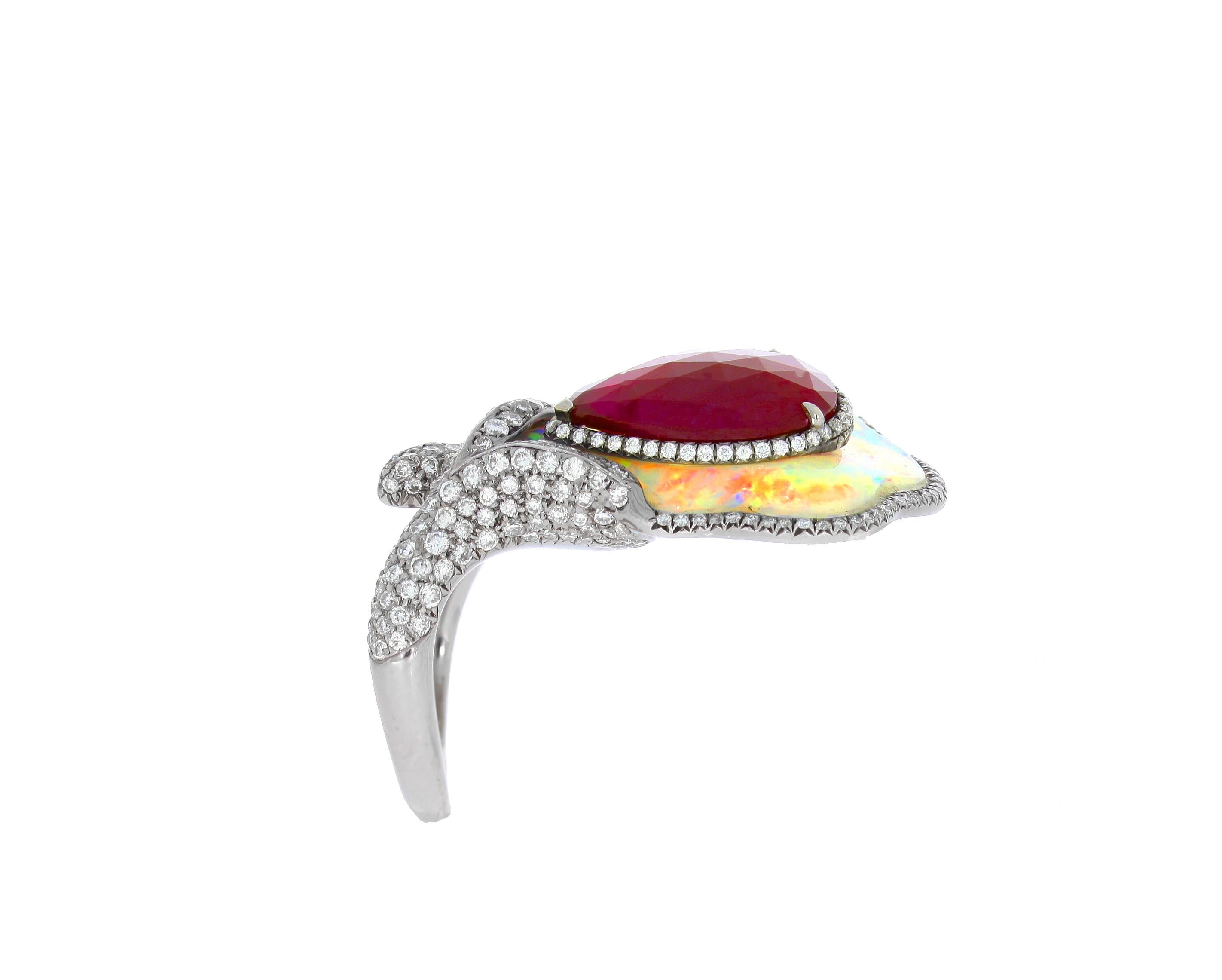 Made from 18 carat white gold, this Chatila ring's play of color on the white opal is enhanced with a 3.54 carat pear shaped ruby in the center, as well as the scintillating white diamonds on its border and band.

Details:

- White opal with a total