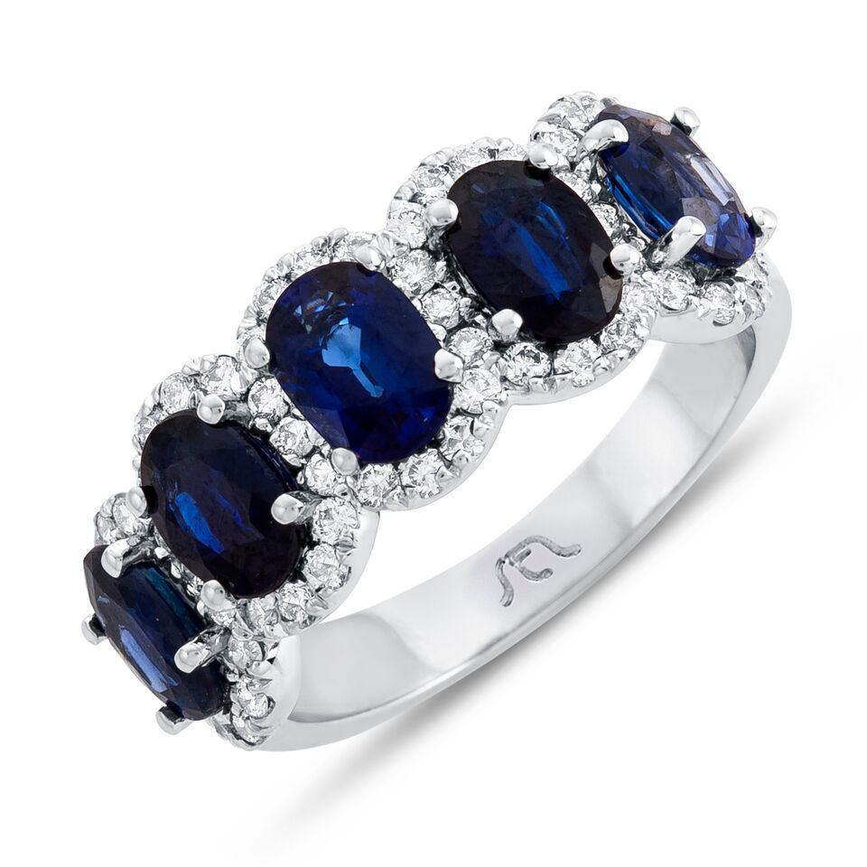 • Crafted in 14KT gold, this band is made with 5 oval cut blue sapphires which are framed by a delicate halo comprised of round brilliant cut diamonds. The band has a combining total weight of approximately 3.55 carats.

Worn beautifully on its own,